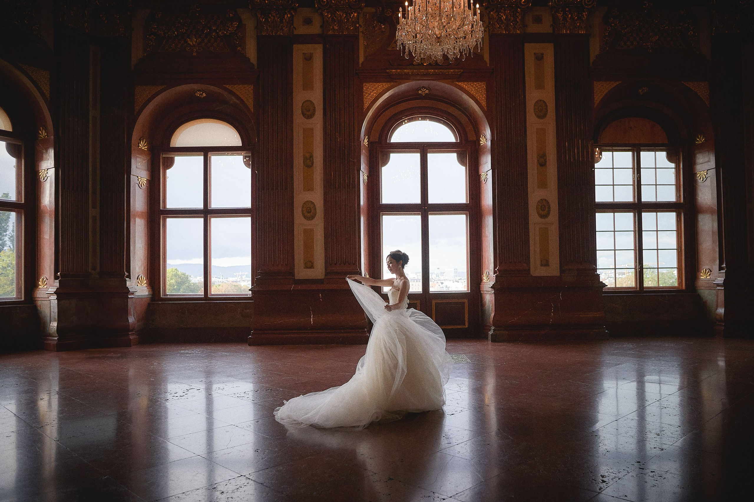 Bride twirls her wedding veil in the historic hall at the Belvedere Palace.
