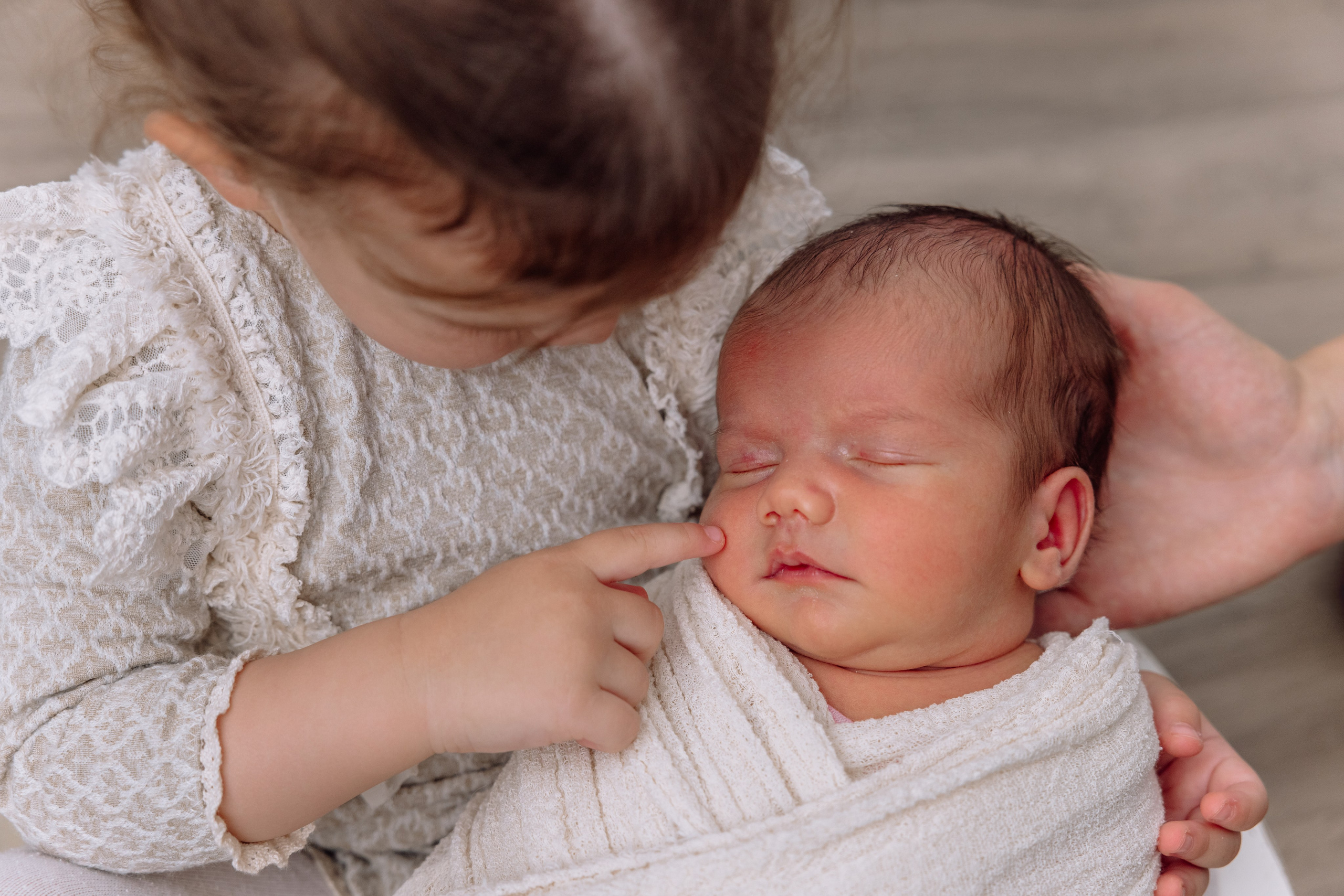 Baby in weißem Outfit mit Stirnband – sanfte Newborn-Fotografie Dachau