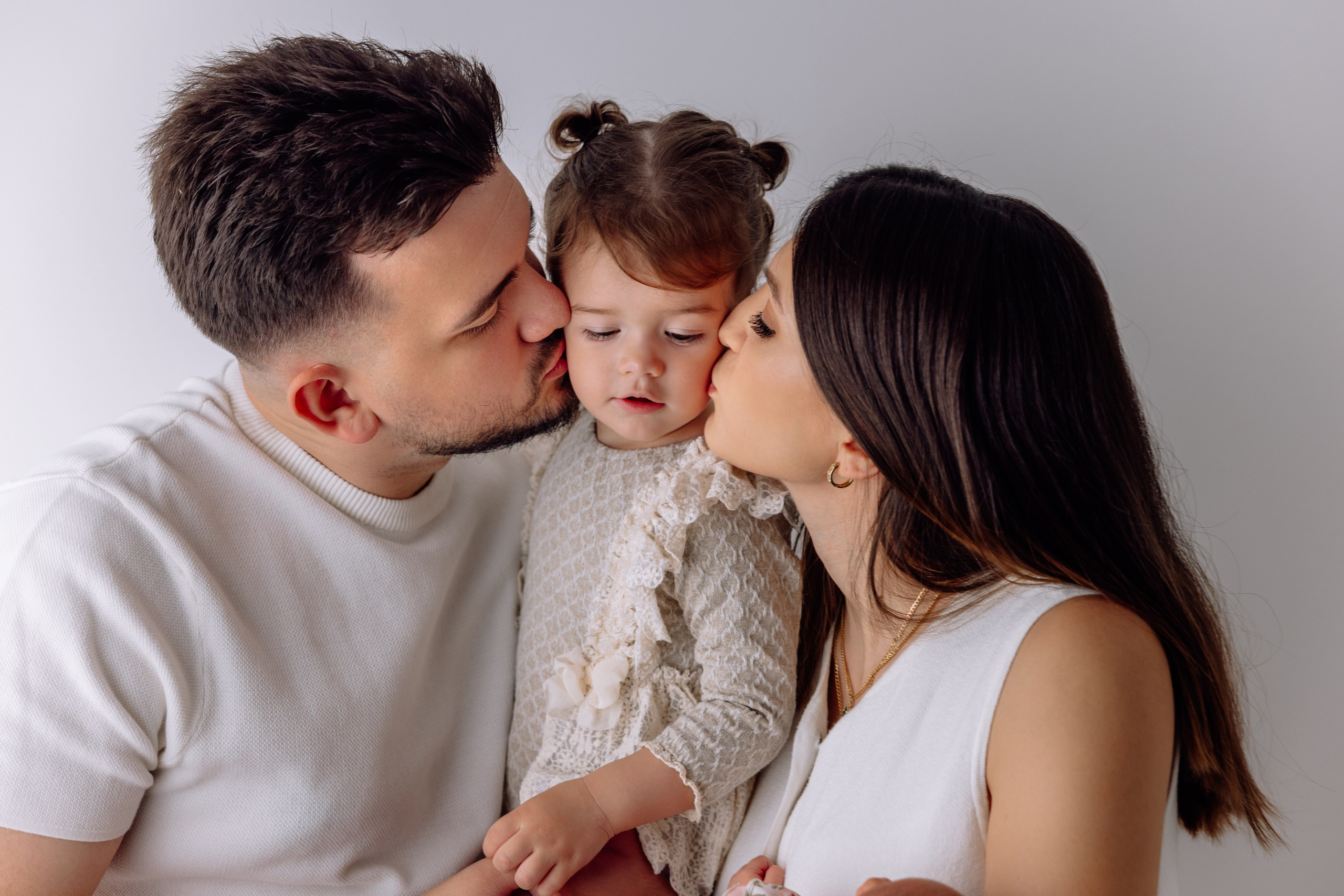 Eltern küssen gemeinsam das Baby – emotionales Familienshooting Dachau