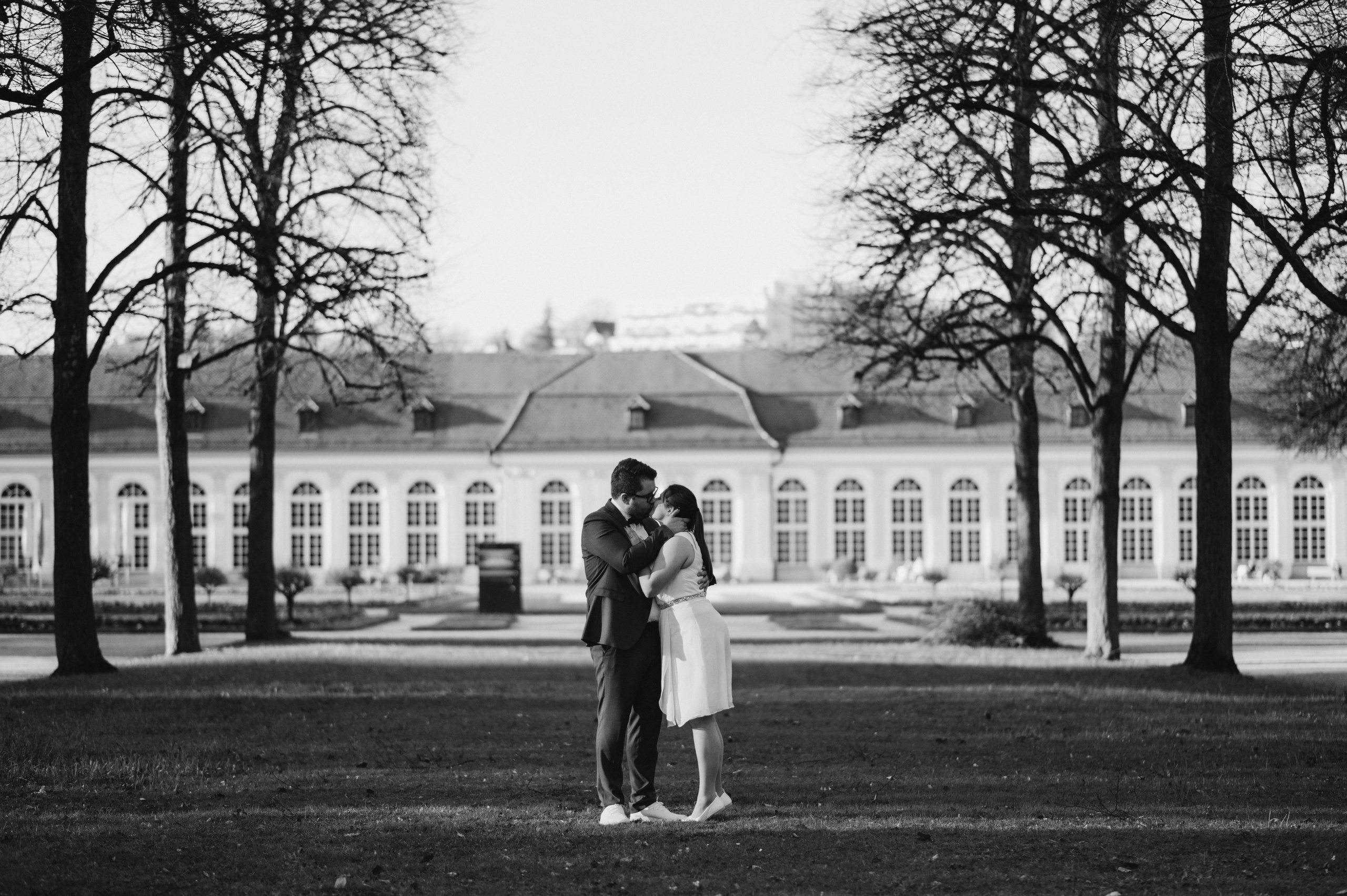 Brautpaar küsst sich vor Orangerie in Ansbach.