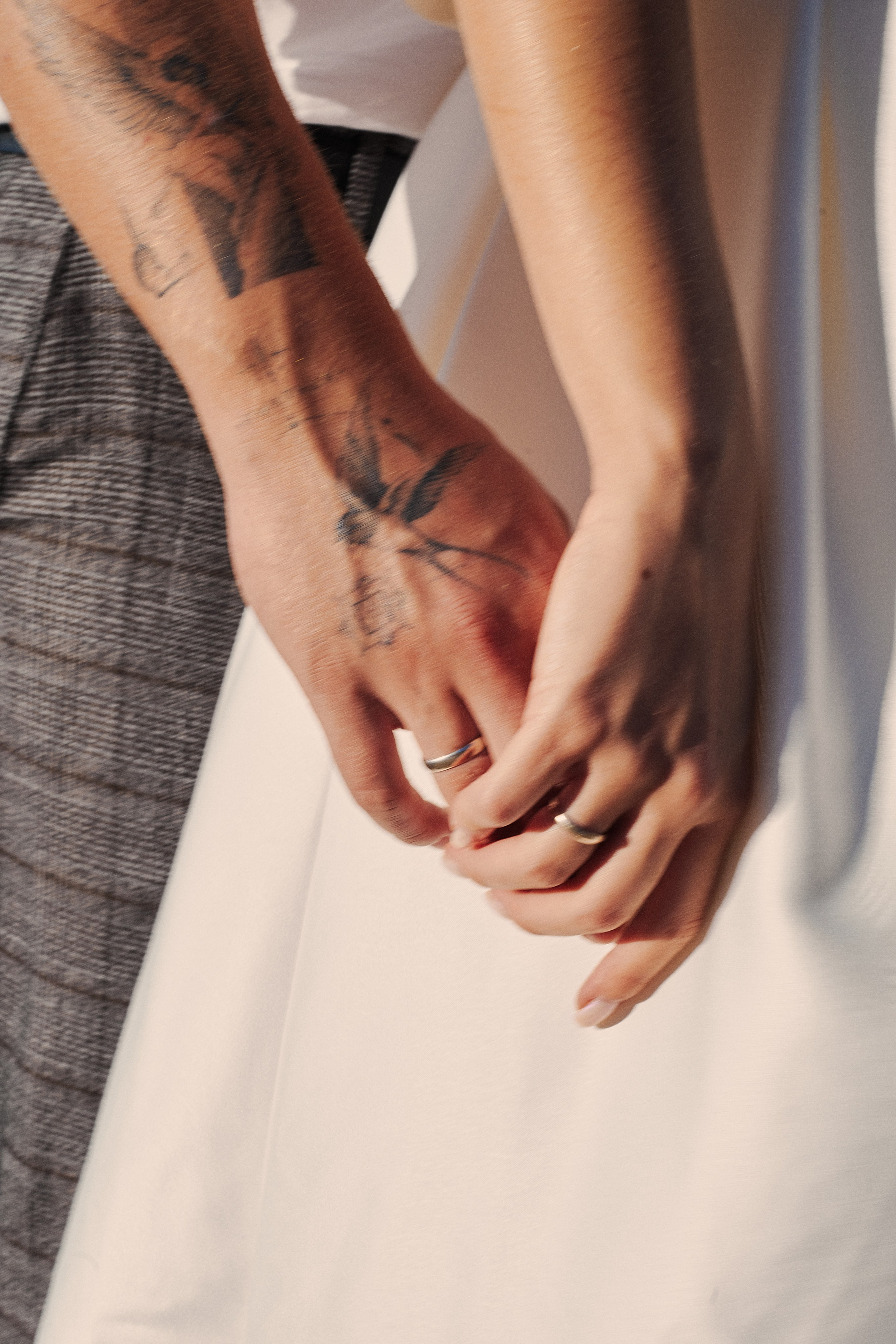 Close shot of hands with rings, bride and groom holding hands