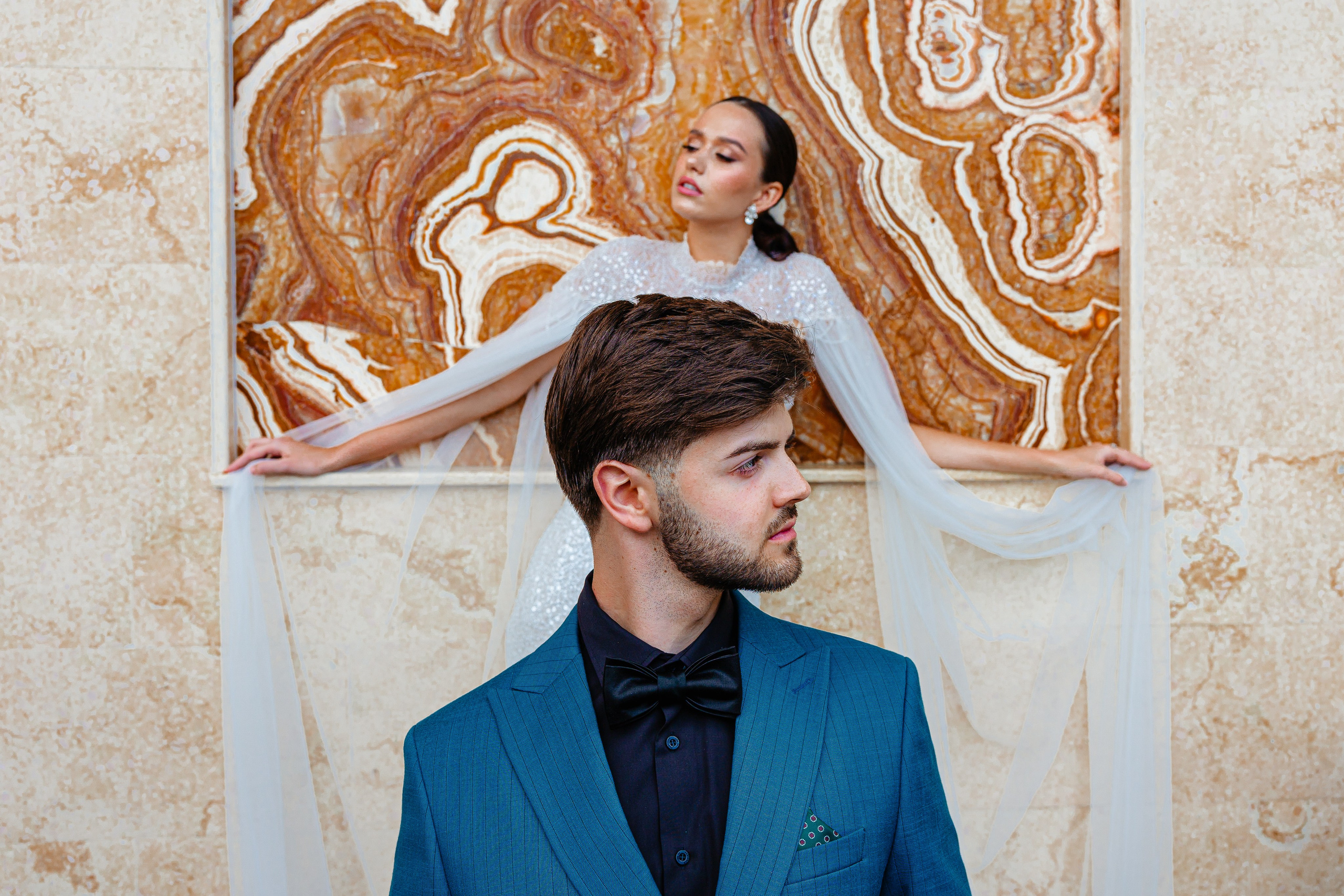 Portret de mire cu fundal marmorat în tonuri calde, privire laterală