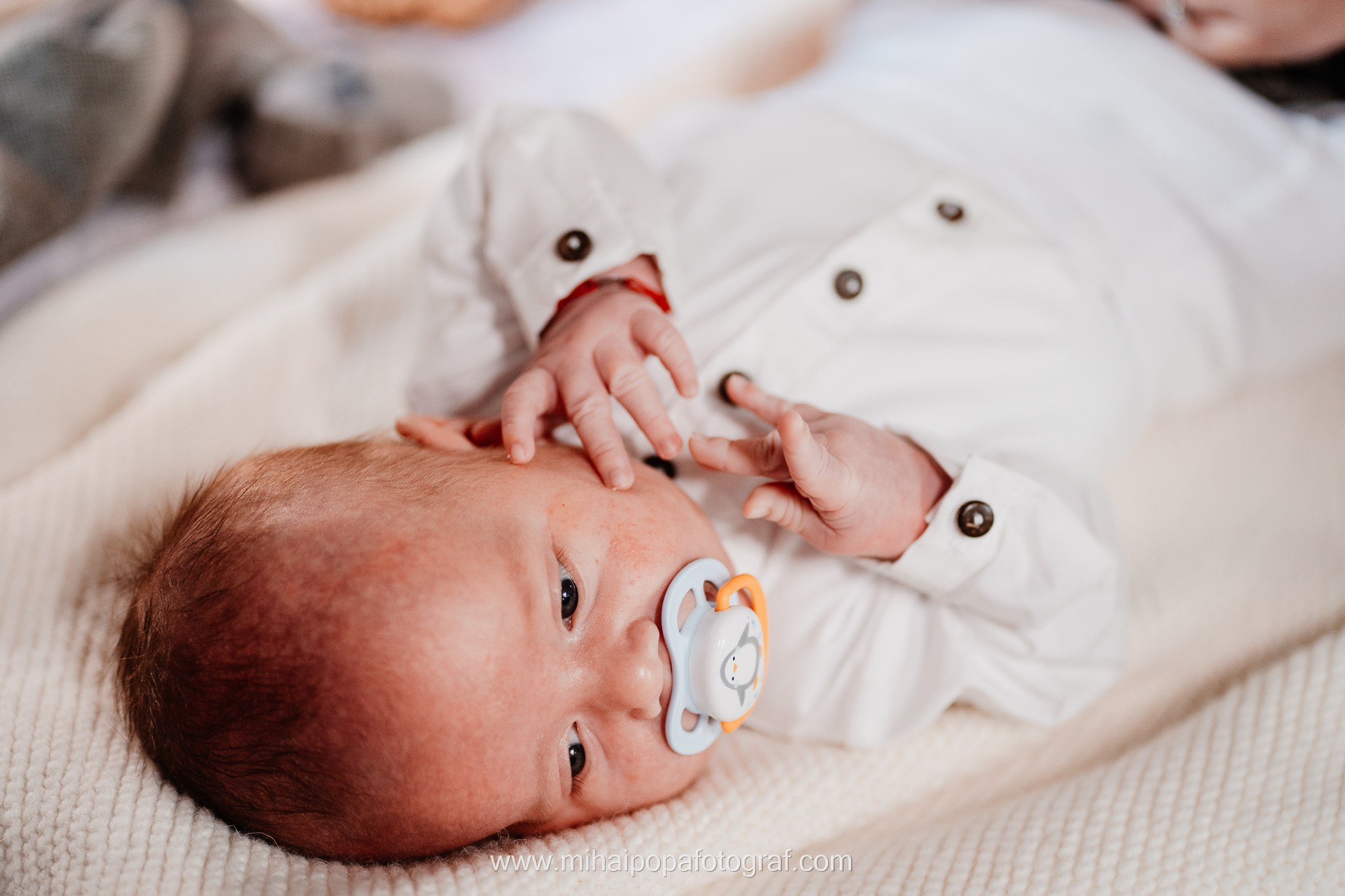 Instantaneu plin de tandrețe dintre părinți și bebeluș în ziua botezului, realizat în ilfov. Fotografie profesională de botez, capturând emoțiile autentice ale familiei într-un decor luminos și cald