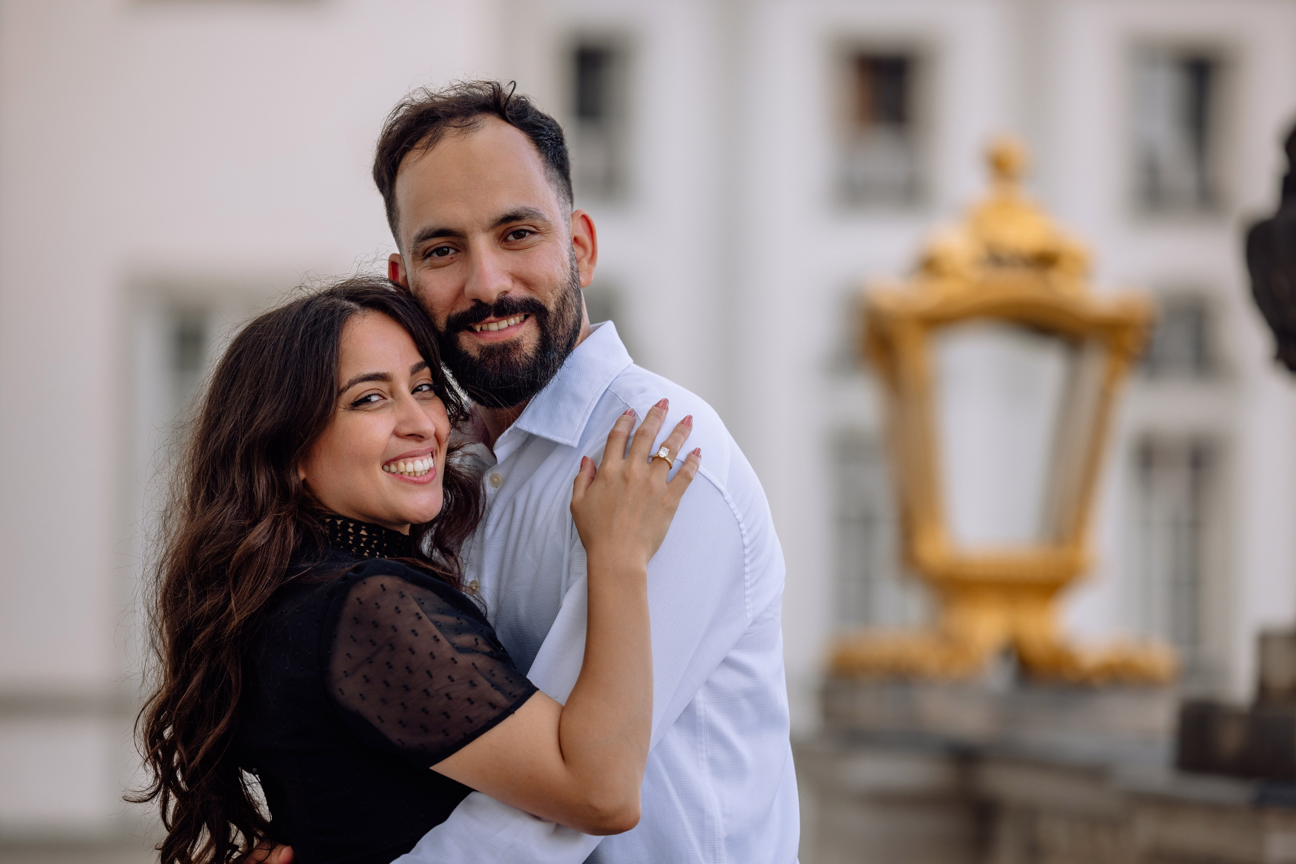 Verlobtes Paar umarmt sich nach dem Antrag vor dem Schloss Nymphenburg