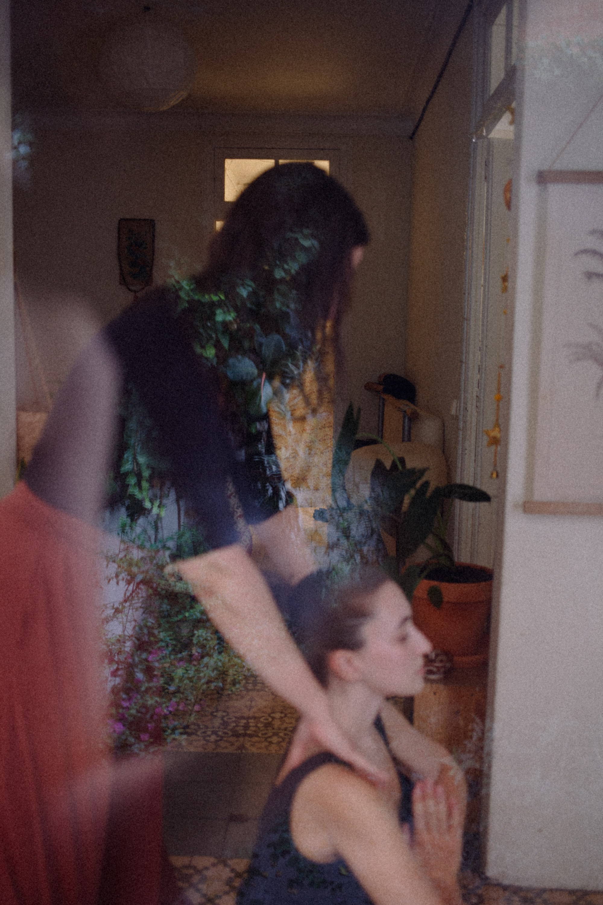 Woman gently placing her hands on another's shoulders in an intimate, calm moment