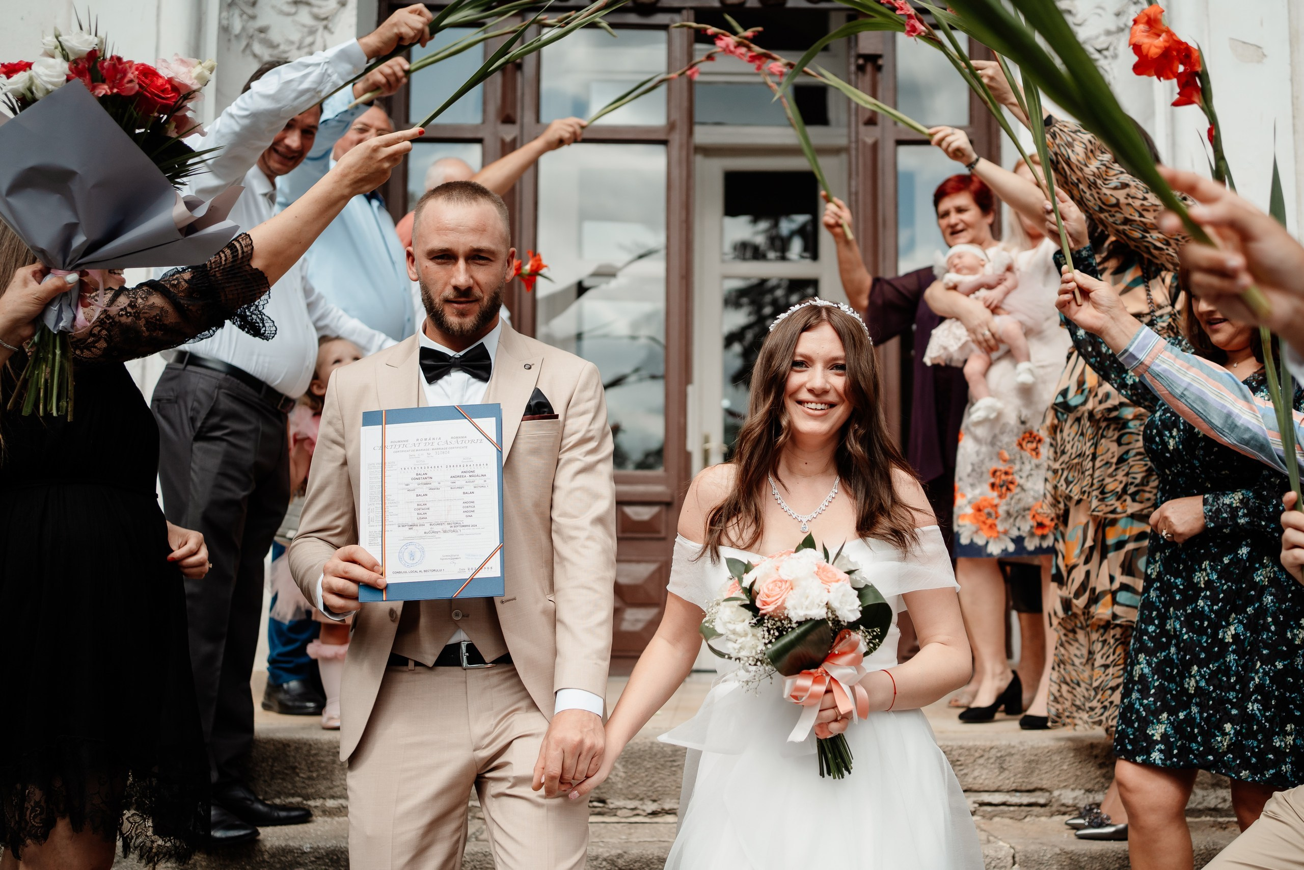 Miri fericiți în fața oficiului stării civile din Bucuresti, Sector 1, celebrând începutul unei noi vieți împreună. Fotografie de cununie civilă, capturând naturalețea și bucuria momentului special.