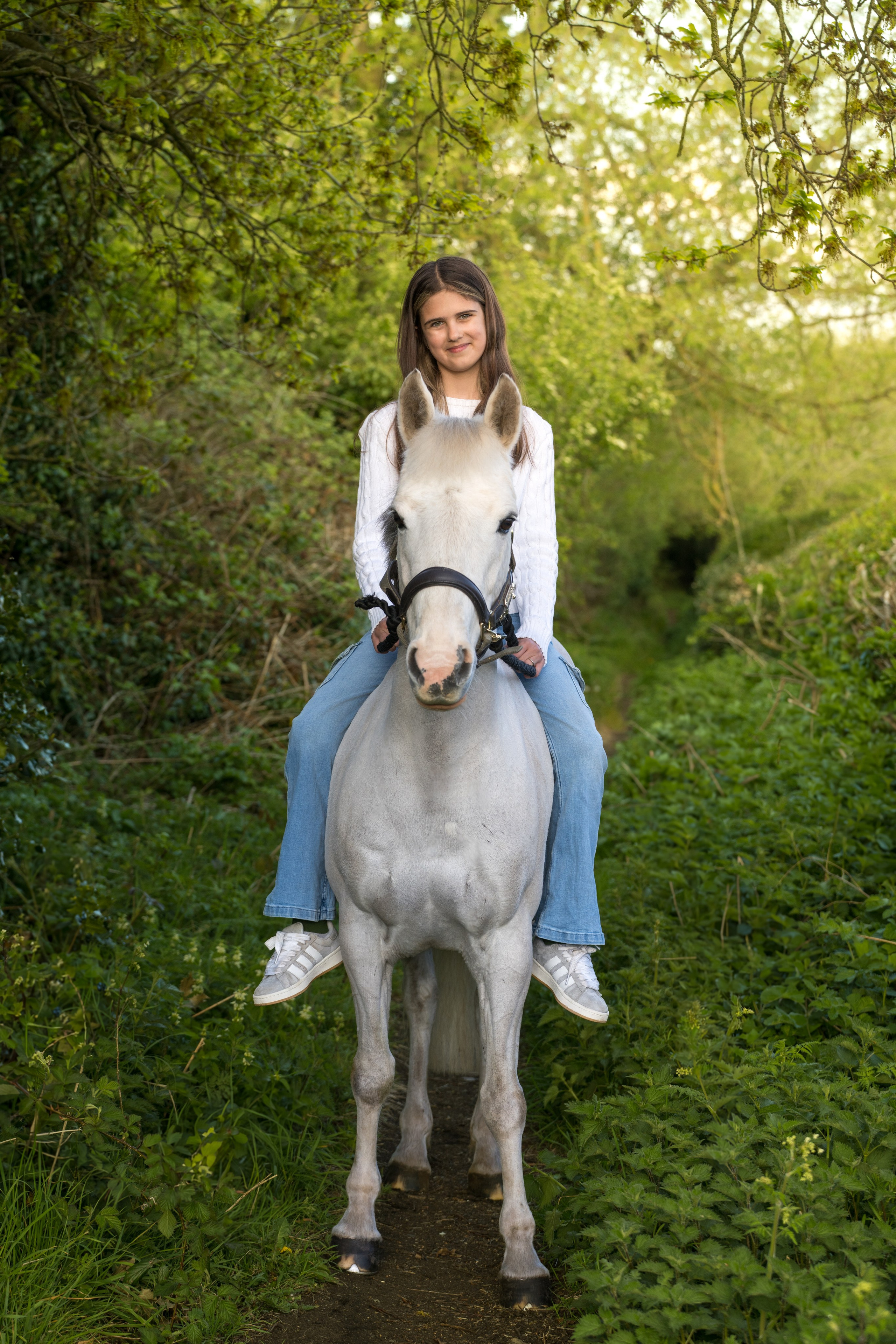 Natural interaction between teenage girl and her horse in open pasture