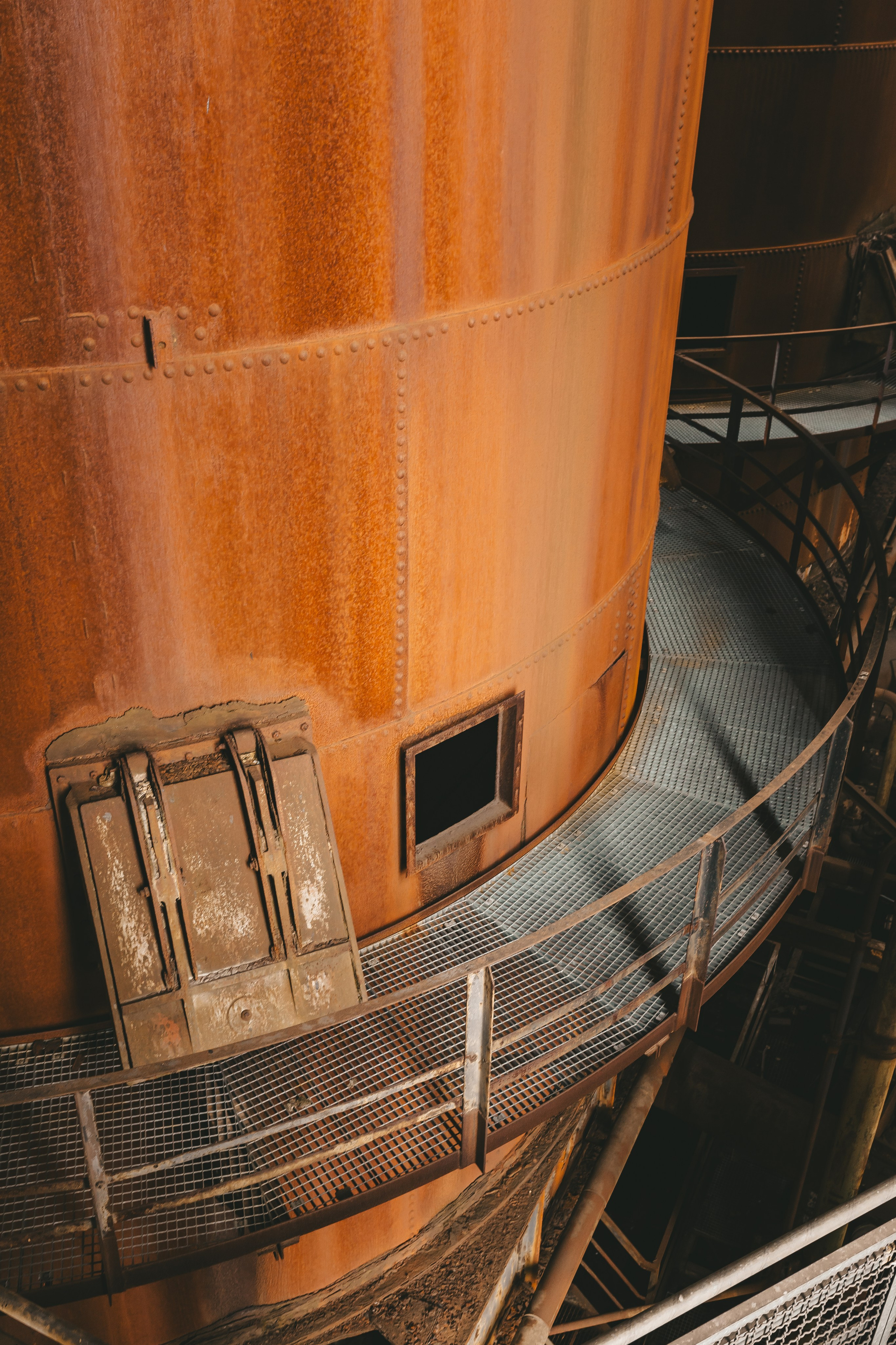 Деталь доменной печи с крупными болтами и ржавой поверхностью.