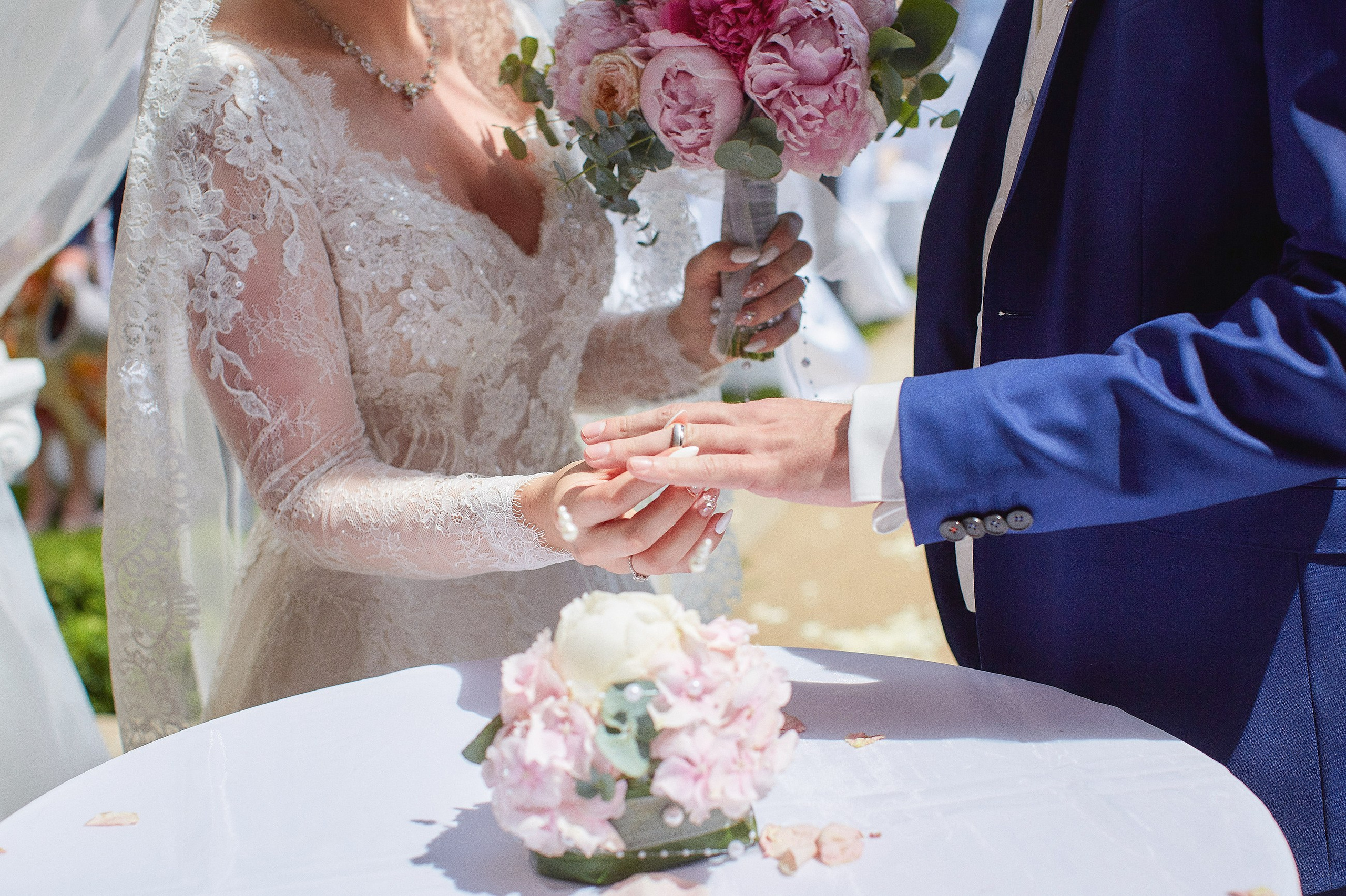 A close up view of the wedding ring as it is placed on the groom's finger during their Ledebour Garden wedding.