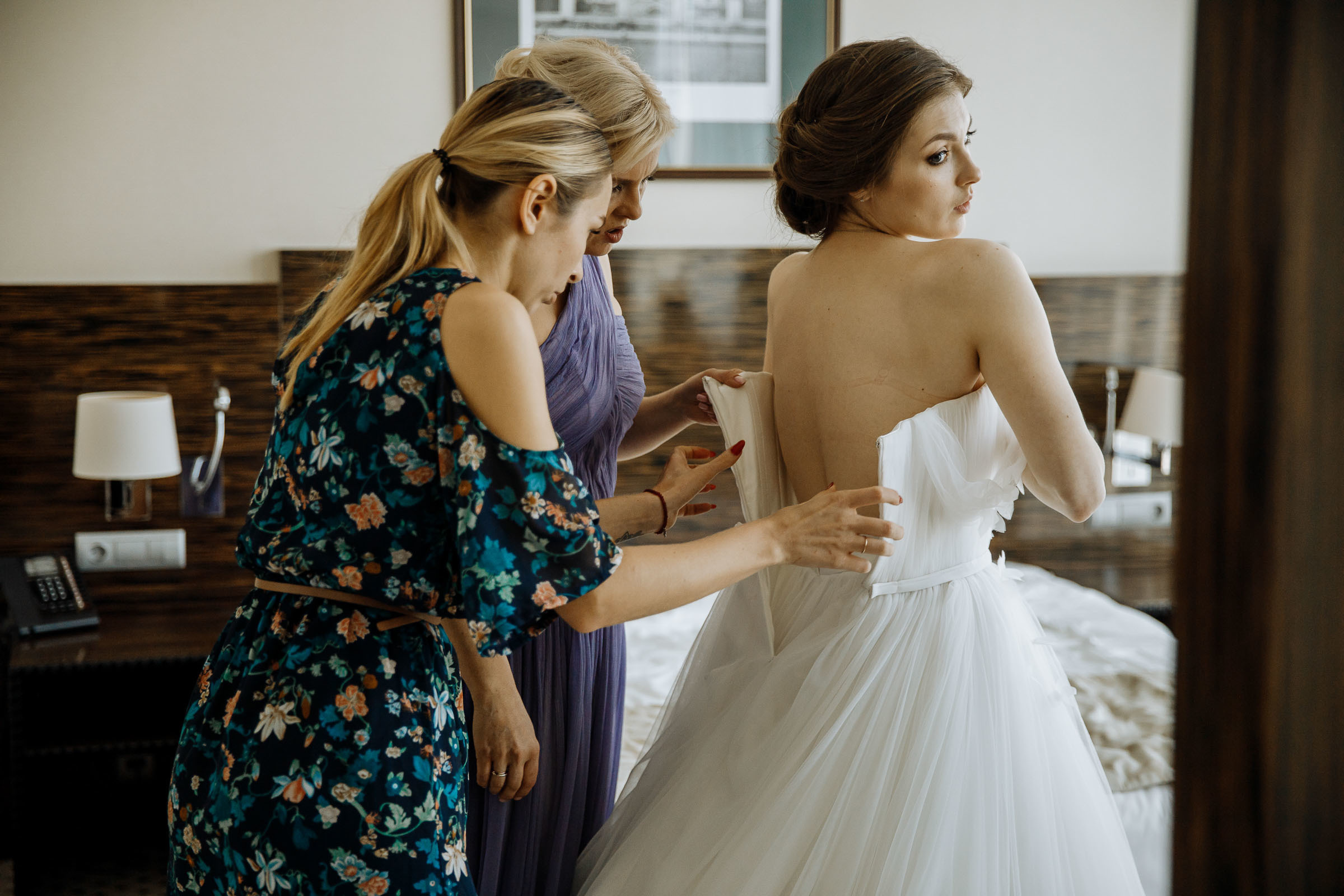 Adjusting dress in suite, by Tanya Bogdan, Bude, Cornwall wedding photographer.  