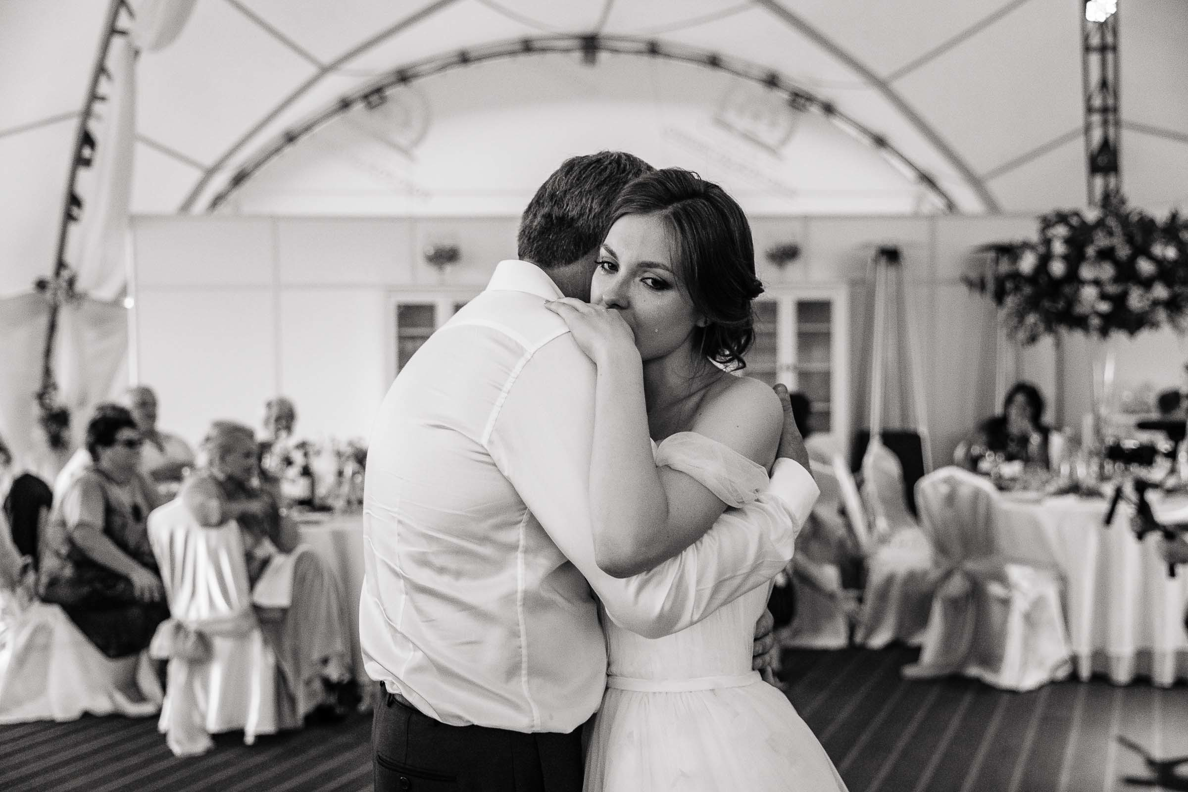 Bride and father embrace under marquee, by Tanya Bogdan, Bude wedding photographer.  