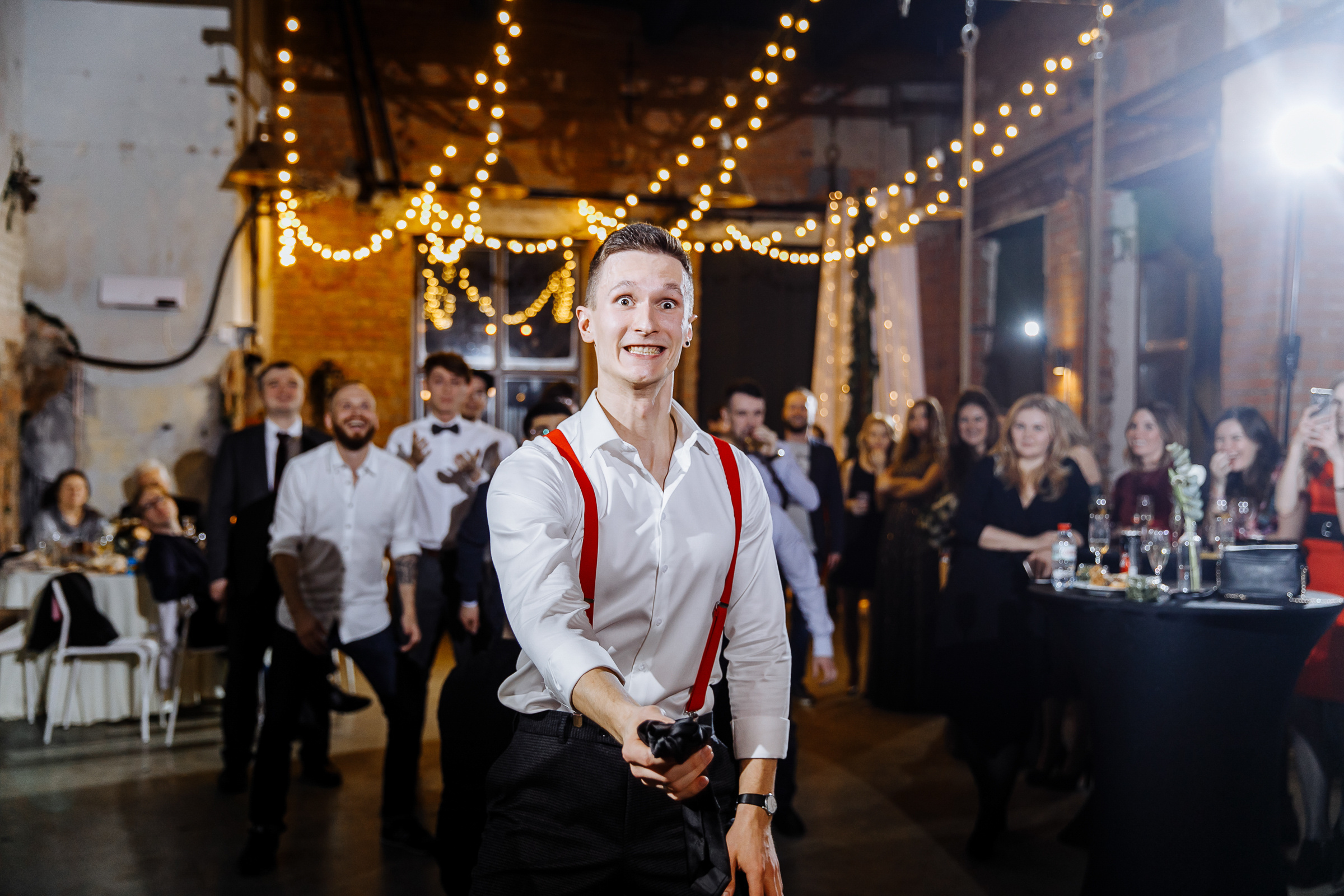 Groom tossing tie in venue, by Tanya Bogdan, Bude, Cornwall wedding photographer.  