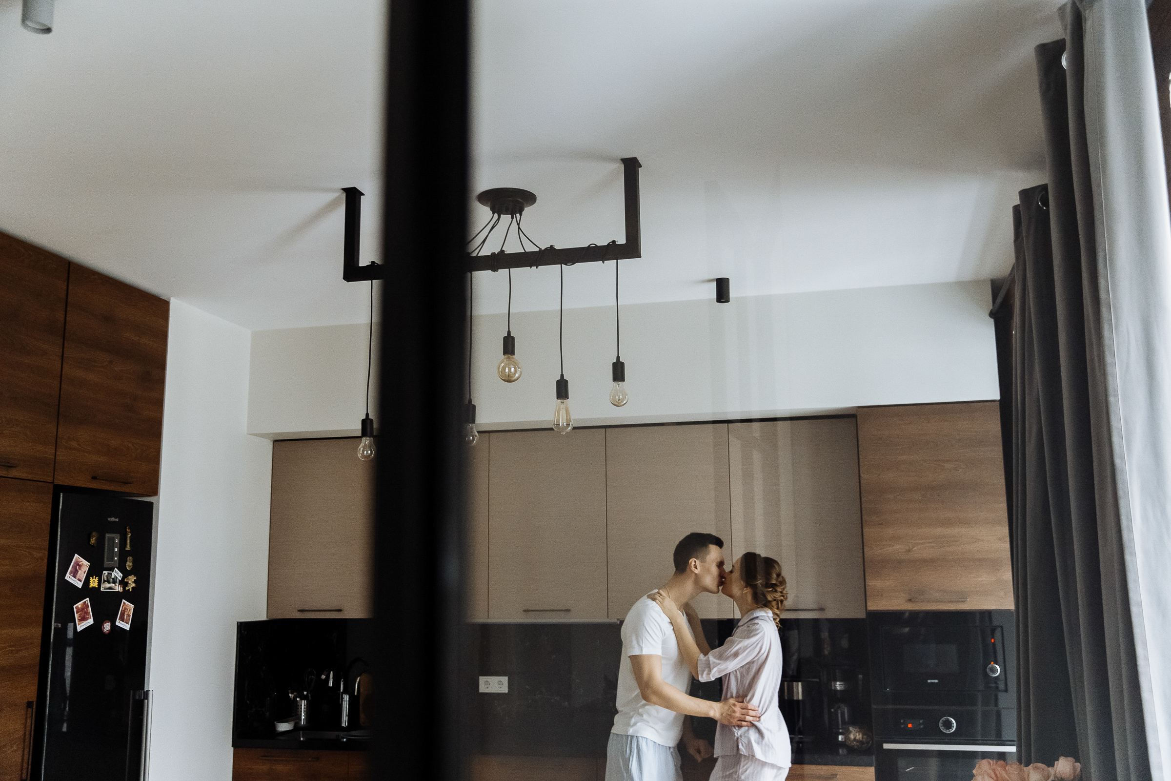 Bride and groom kissing in kitchen, by Tanya Bogdan, Bude, Cornwall wedding photographer.  