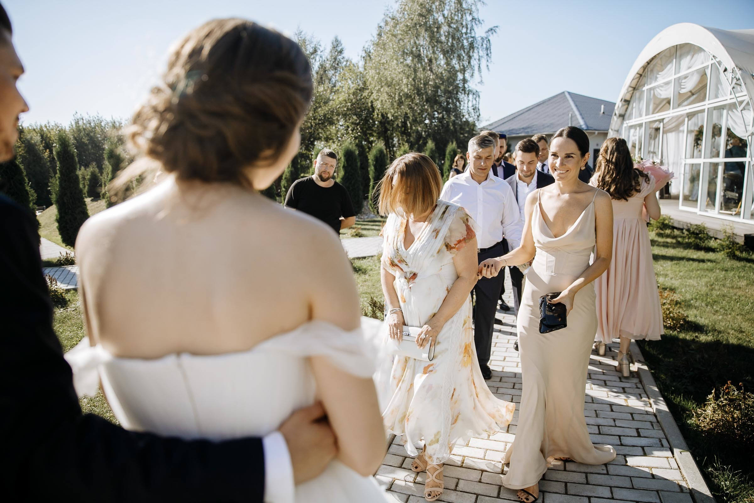 Guests emotional after ceremony in garden, by Tanya Bogdan, Bude reportage wedding photographer.  