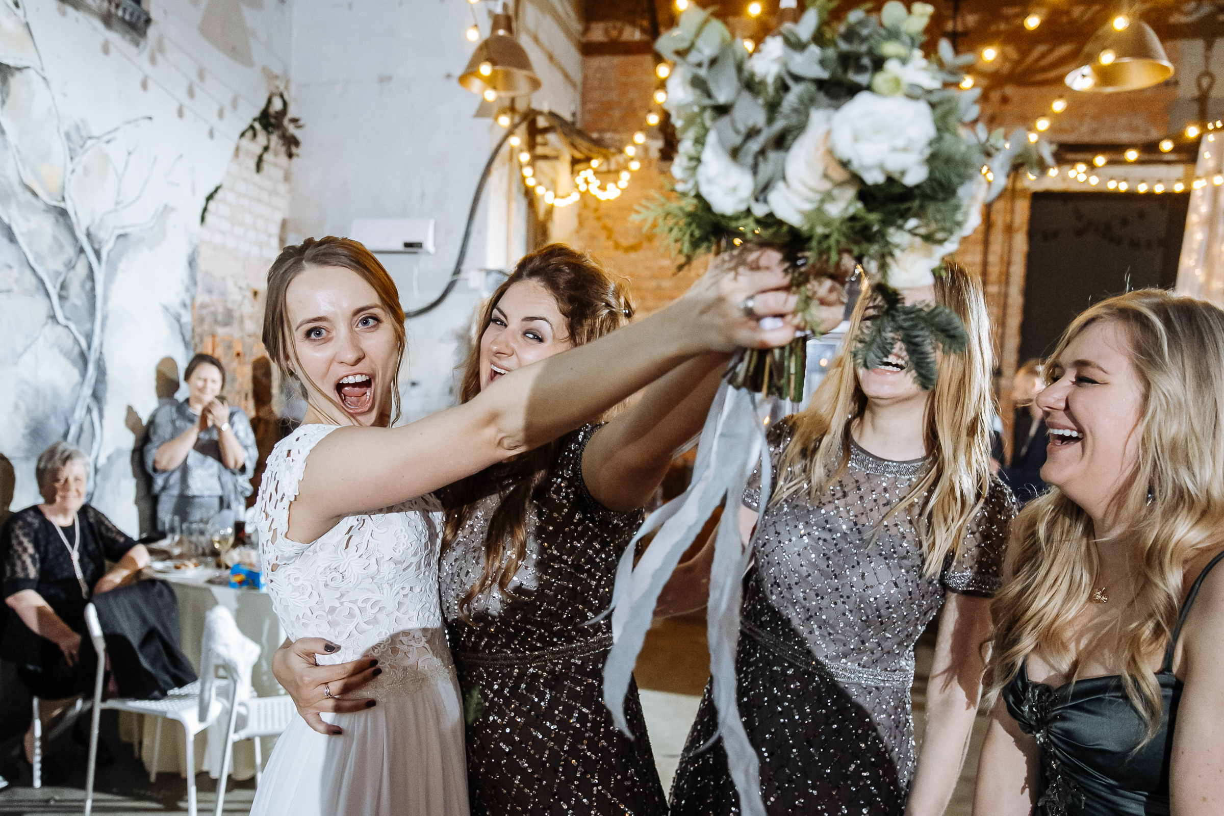 Bride cheering at bouquet toss, by Tanya Bogdan, city wedding photography.