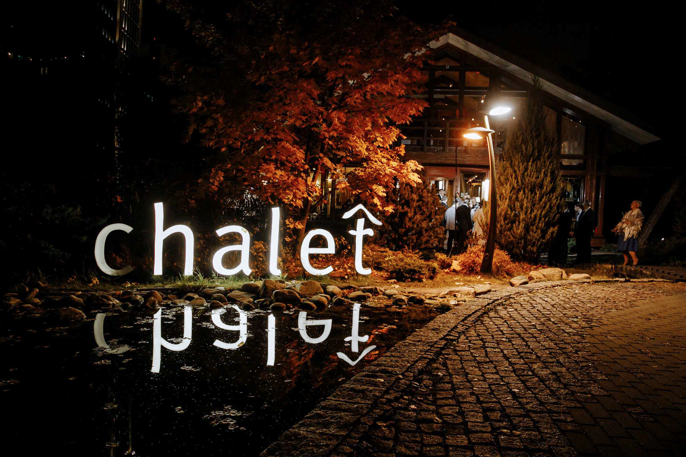 Chalet venue with lit-up name at night, by Tanya Bodgan, Bude, Cornwall wedding photographer.