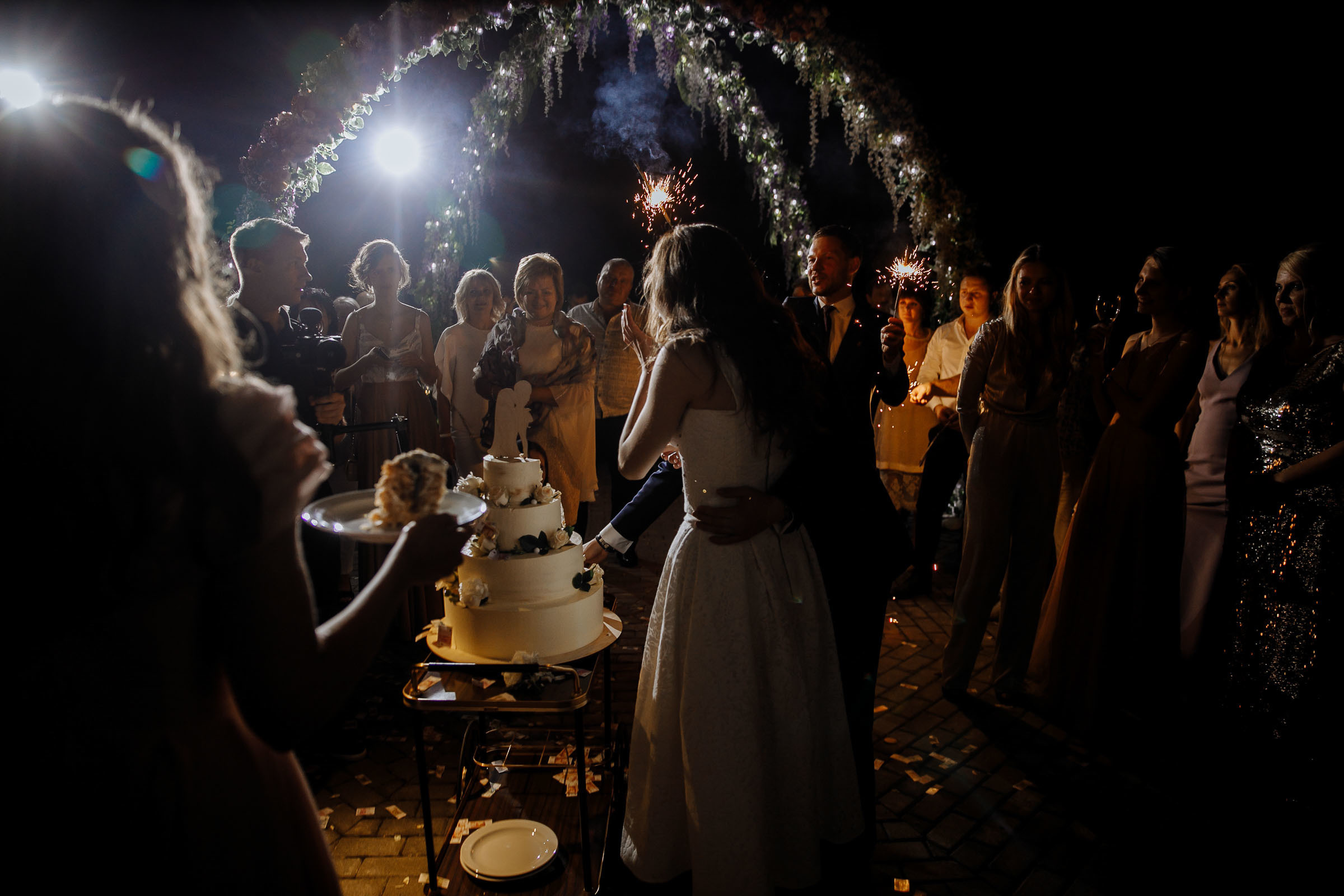 The cake cut from behind, by Tanya Bogdan, Bude editorial and reportage wedding photography.  