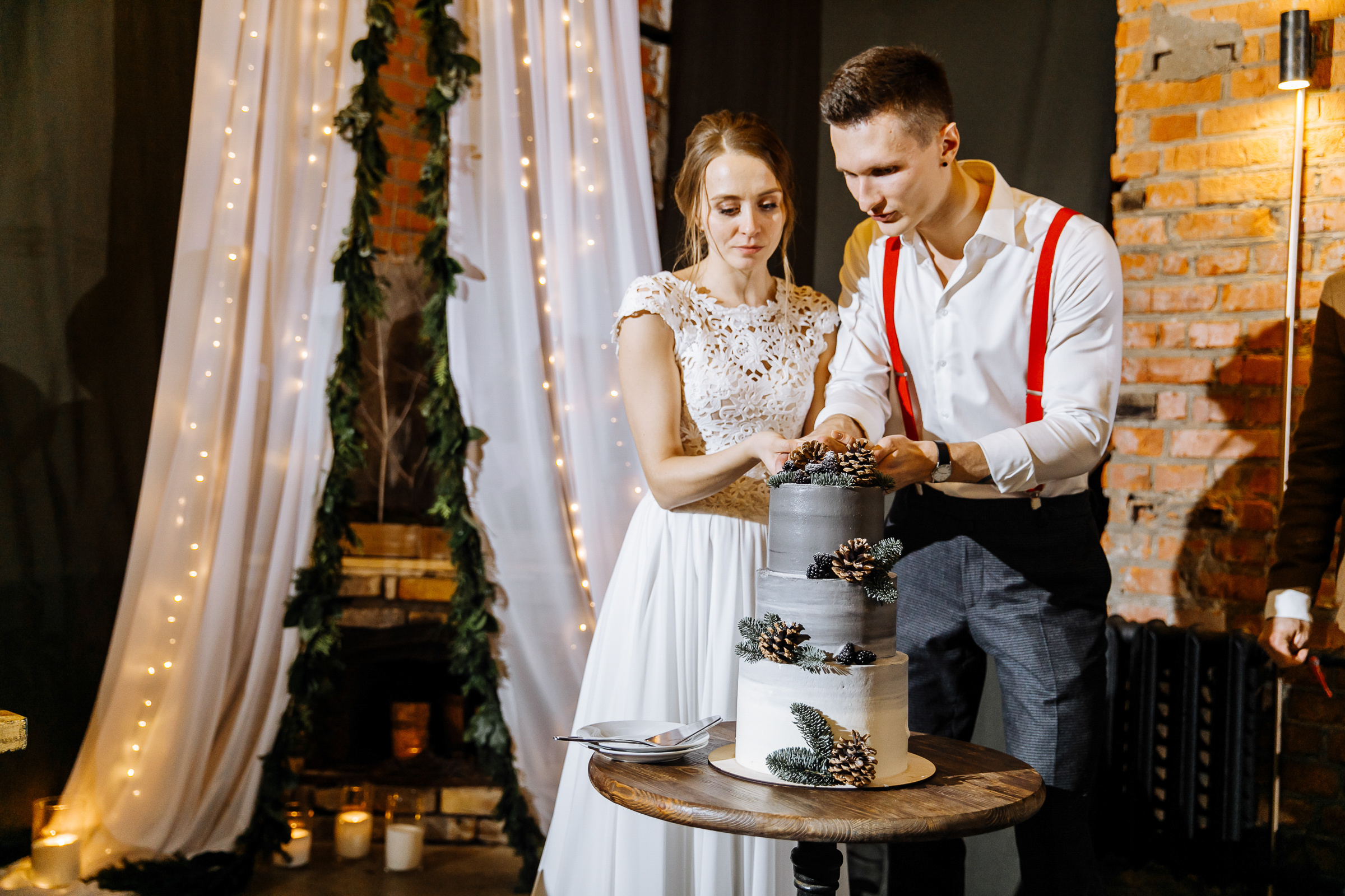 Couple cutting cake in venue, by Tanya Bogdan, St Ives wedding photography.  