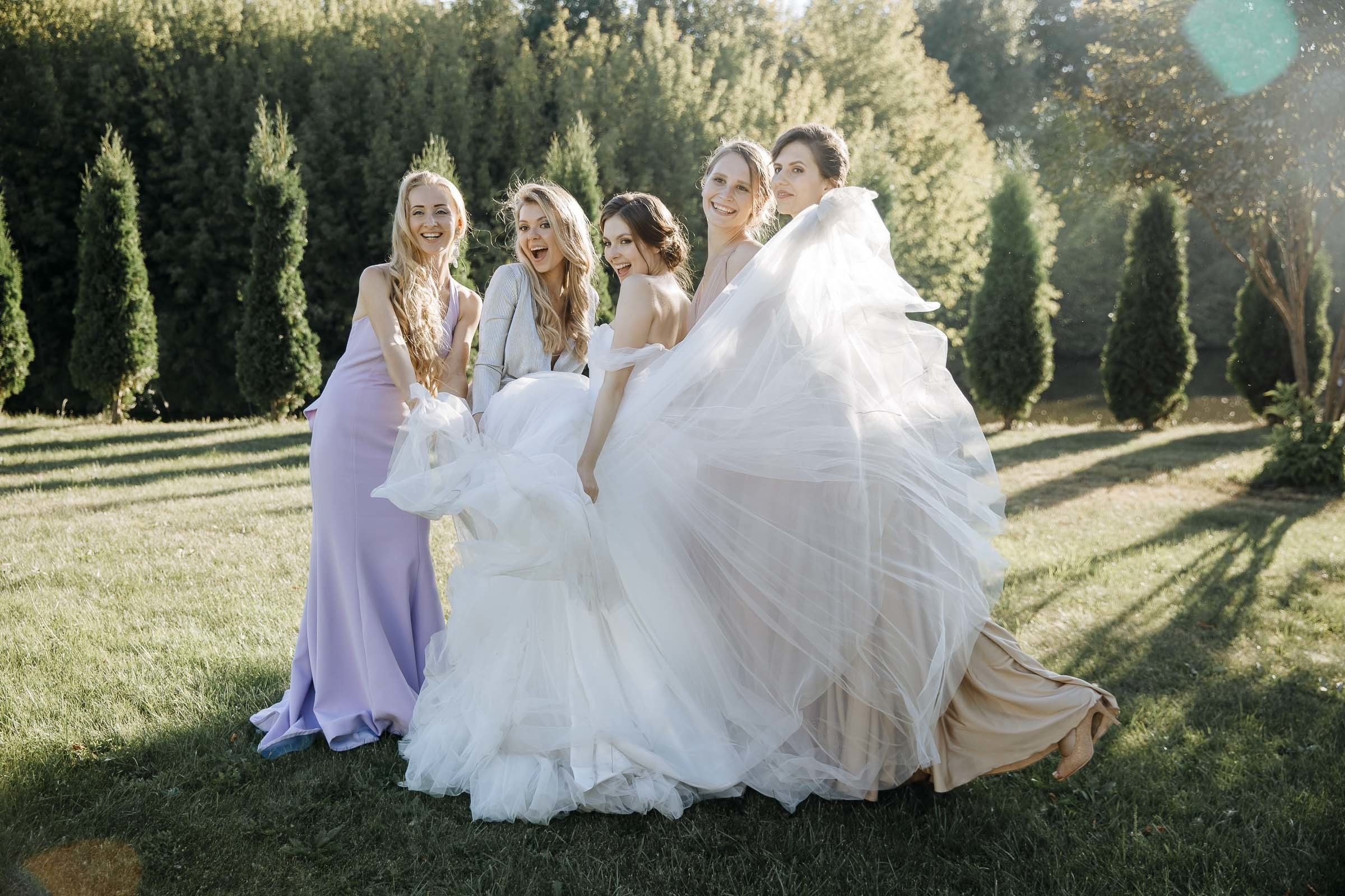Bride and bridesmaids pose in meadow, by Tanya Bogdan, Truro wedding photographer.  