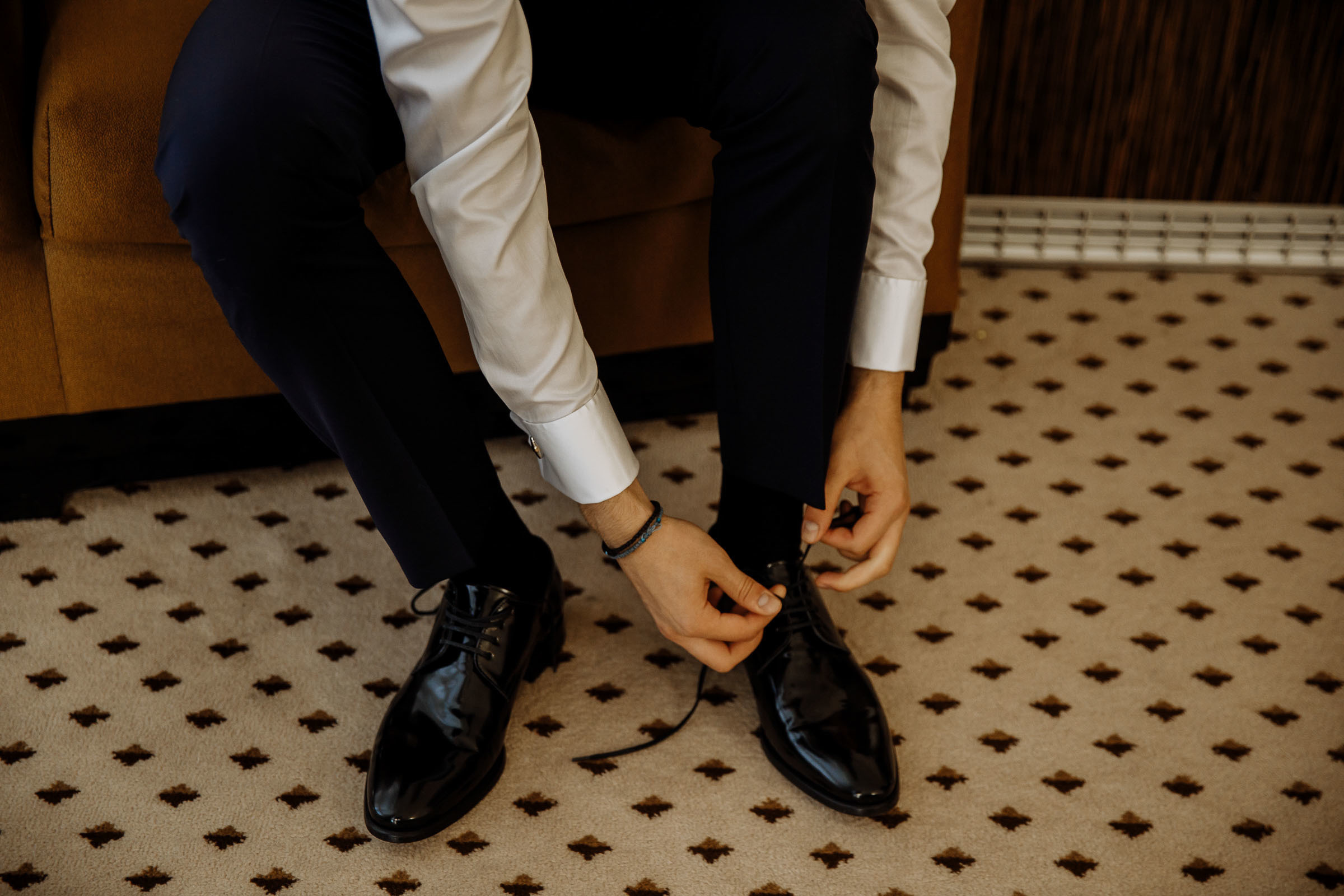 Groom putting on shoes, by Tanya Bogdan, Exeter wedding photographer.  