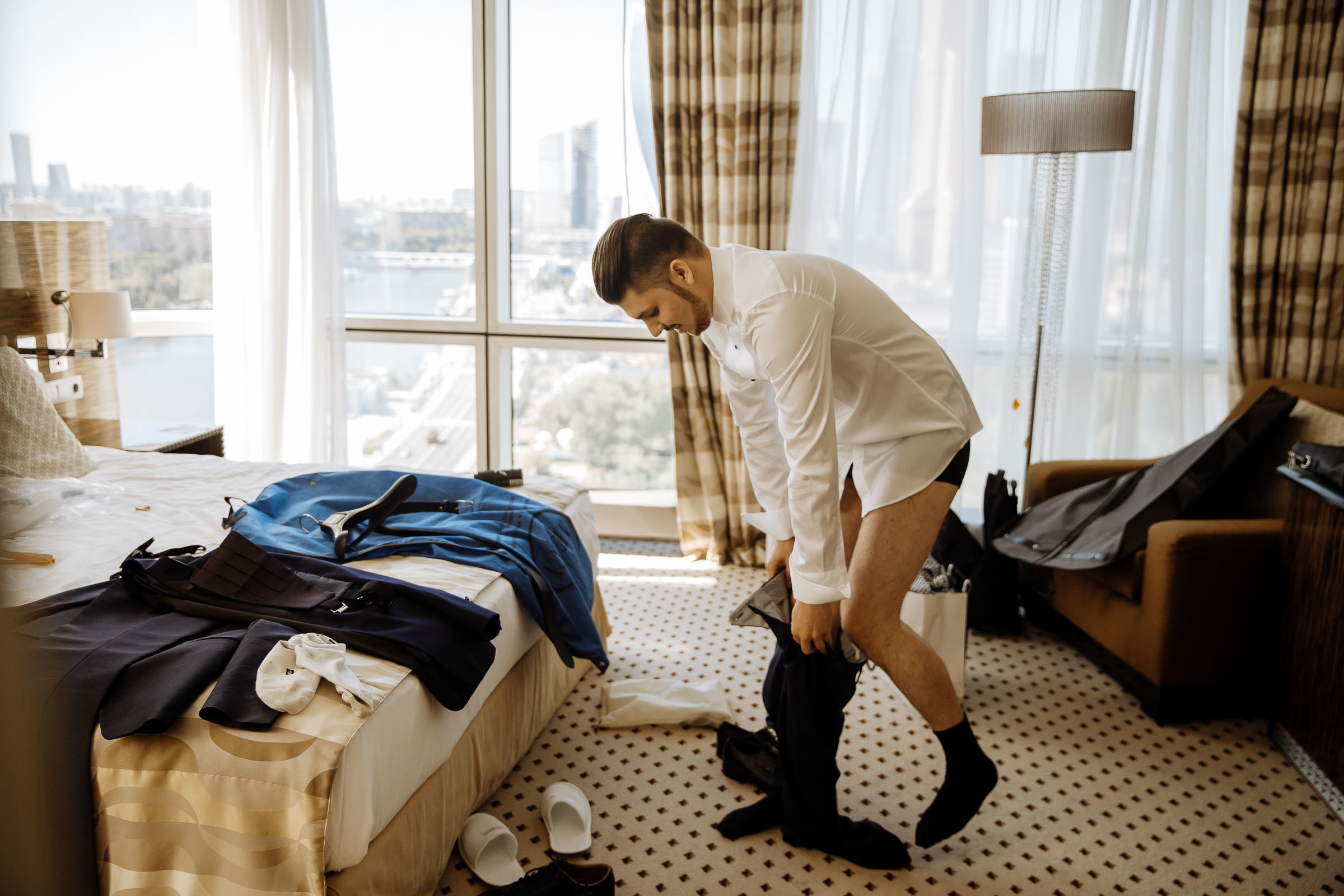 Groom’s candid prep in suite, by Tanya Bogdan, Plymouth wedding photography.  
