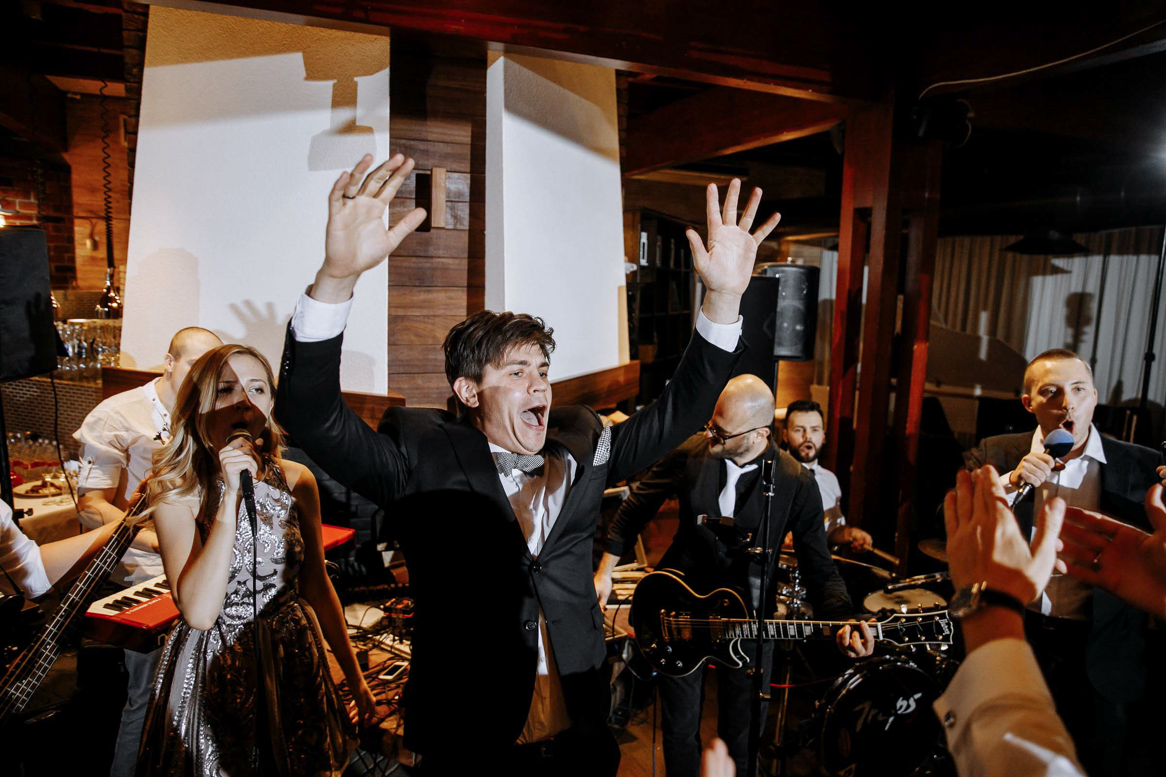 Guests cheering on dance floor, by Tanya Bodgan, Plymouth editorial wedding photographer.  