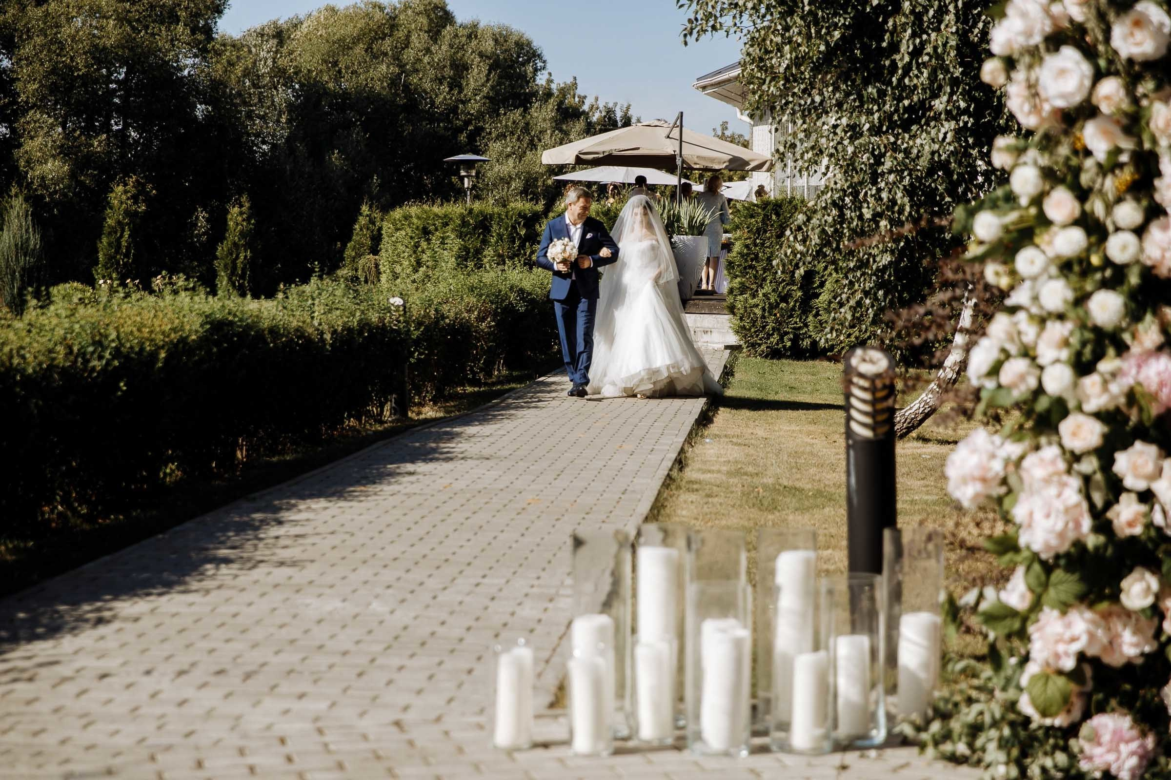 Bride walking down aisle in garden, by Tanya Bogdan, Bude, Cornwall wedding photographer.  