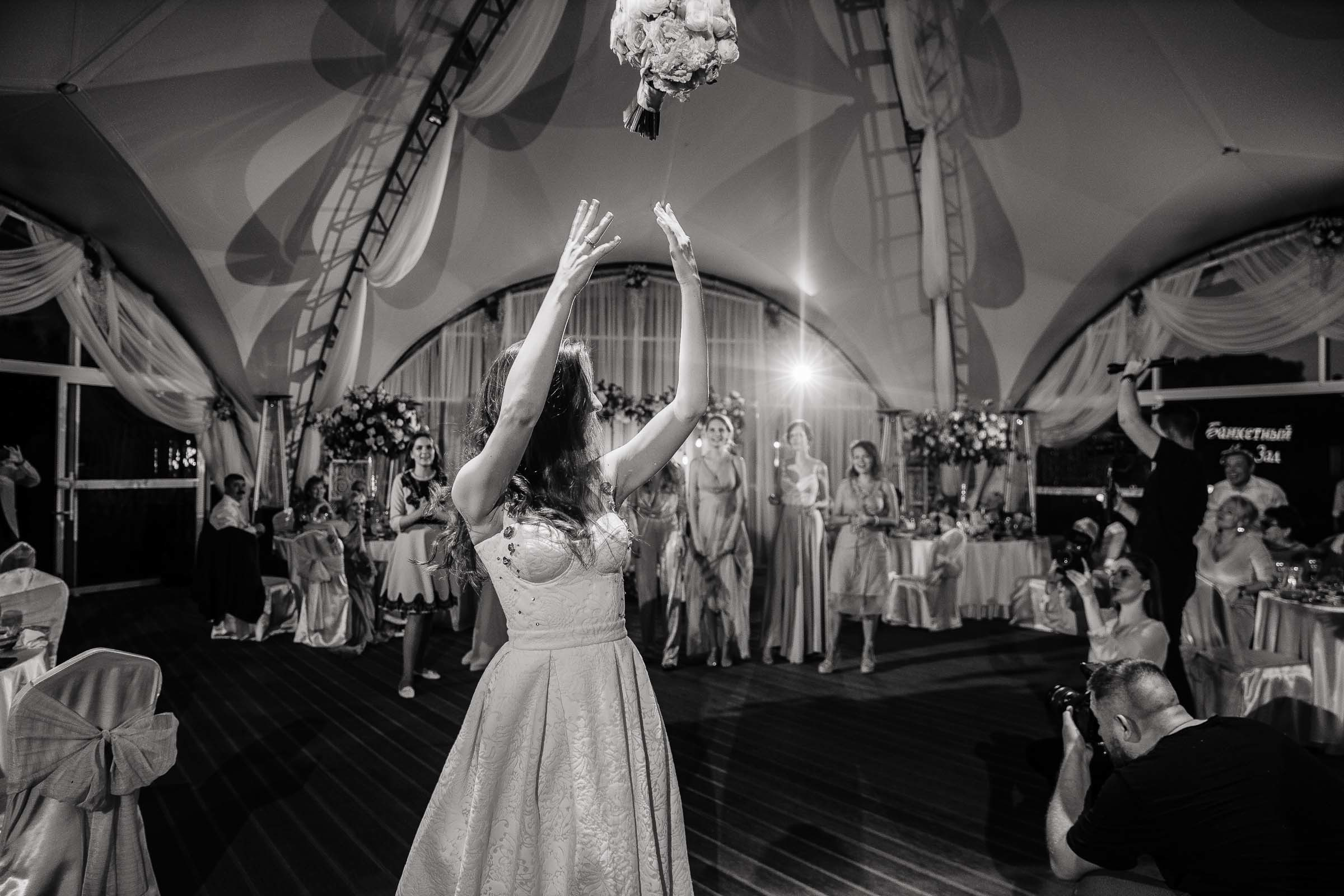 Bride tossing bouquet in black and white, by Tanya Bogdan, Bude wedding photography.  