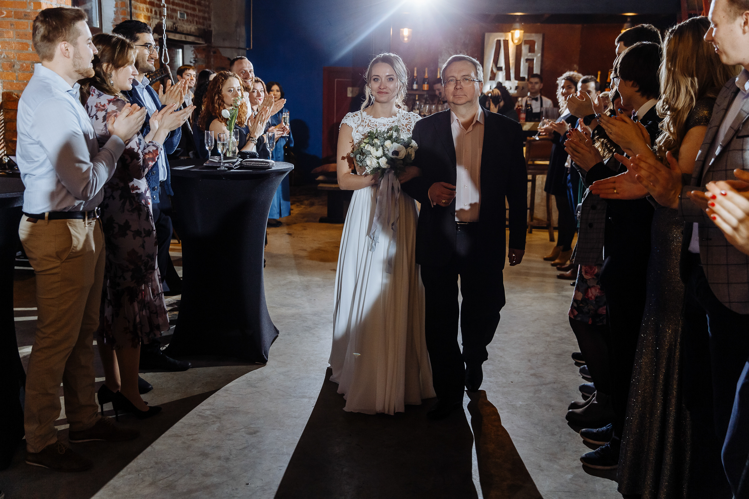 Bride walking down aisle with father in city venue, by Tanya Bogdan, Bude, Cornwall wedding photographer.  