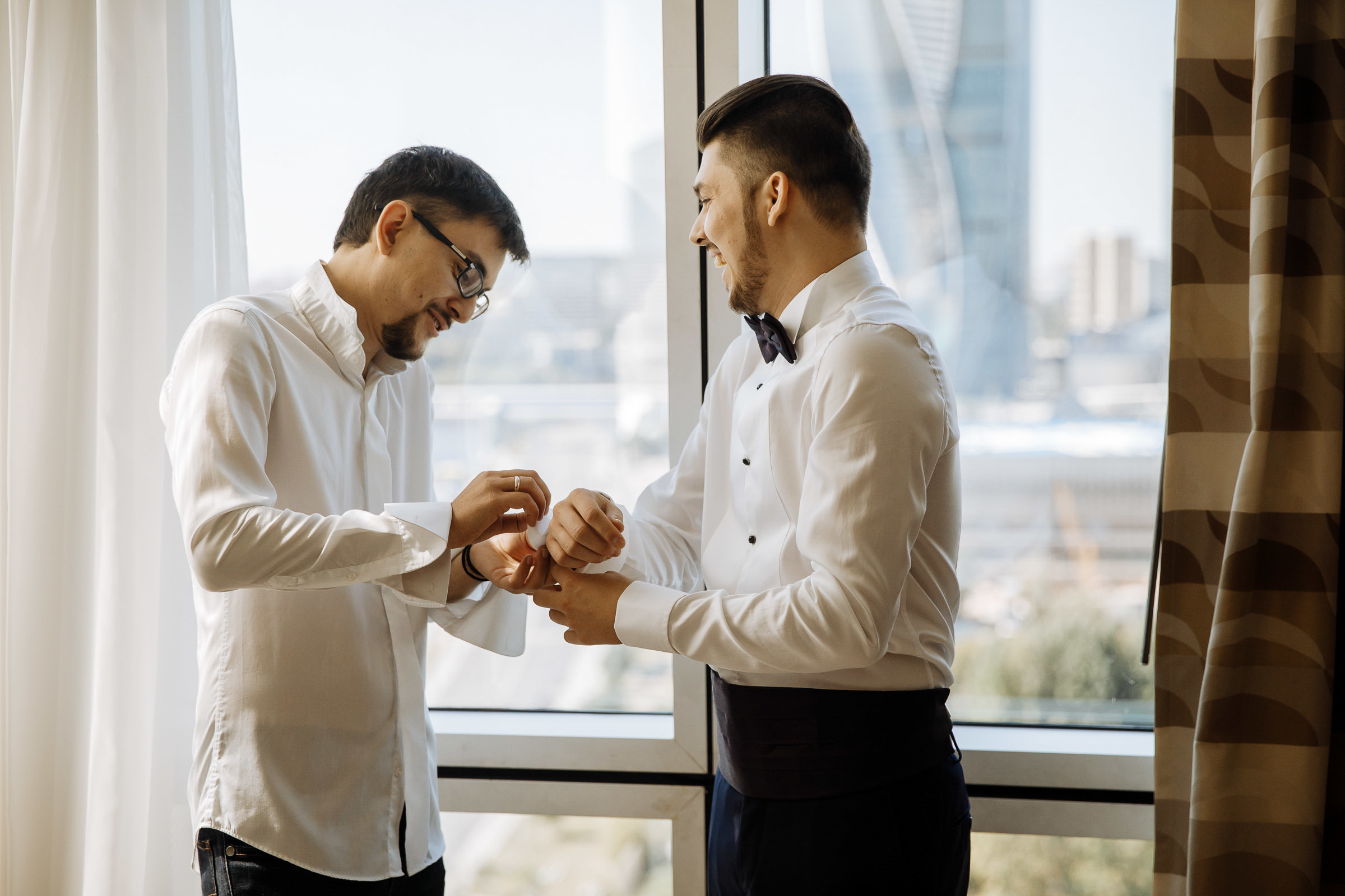 Groomsmen adjusting cufflinks, by Tanya Bogdan, Bude, Cornwall editorial wedding photographer.  