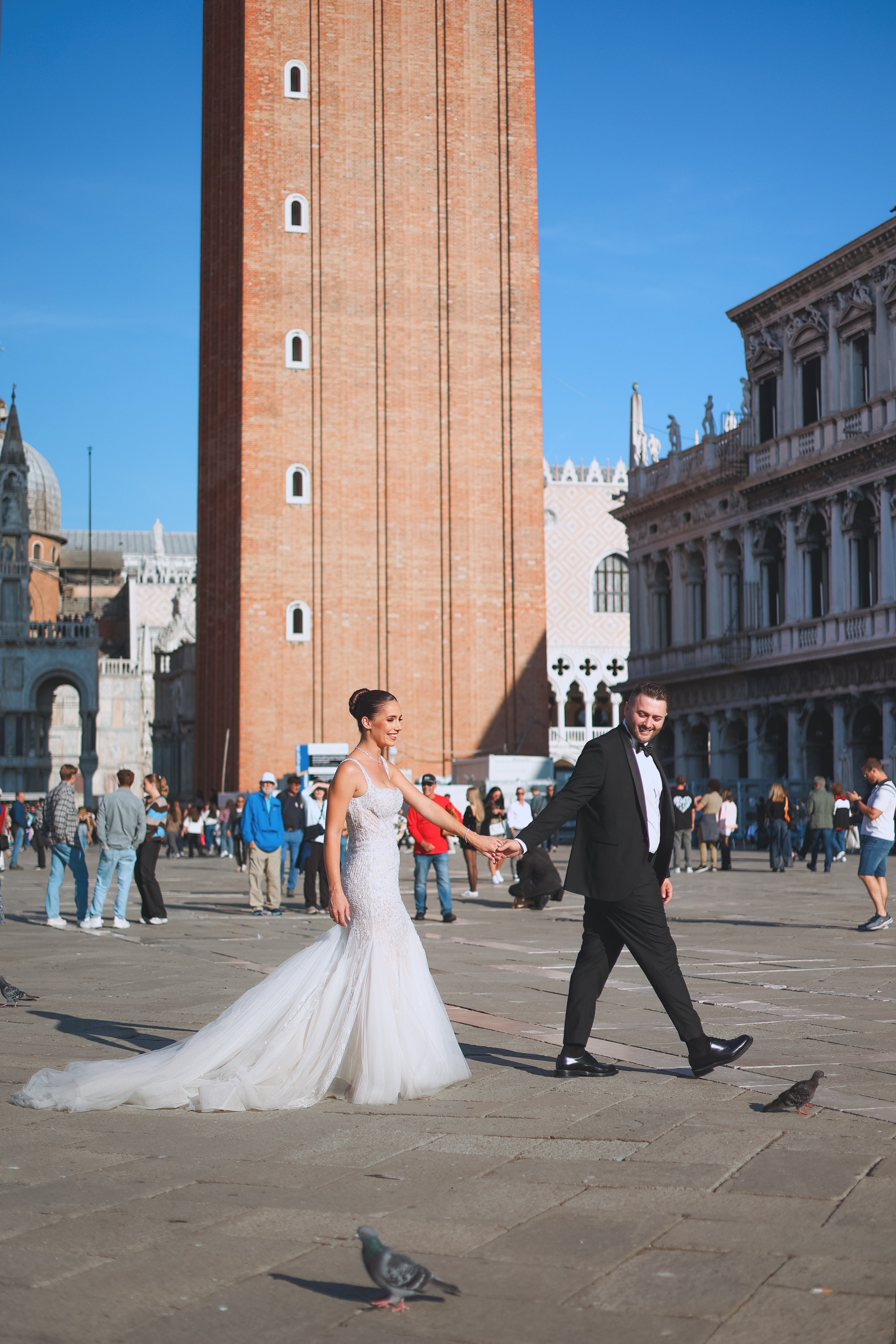 Couple on their wedding day walking across a Venice square