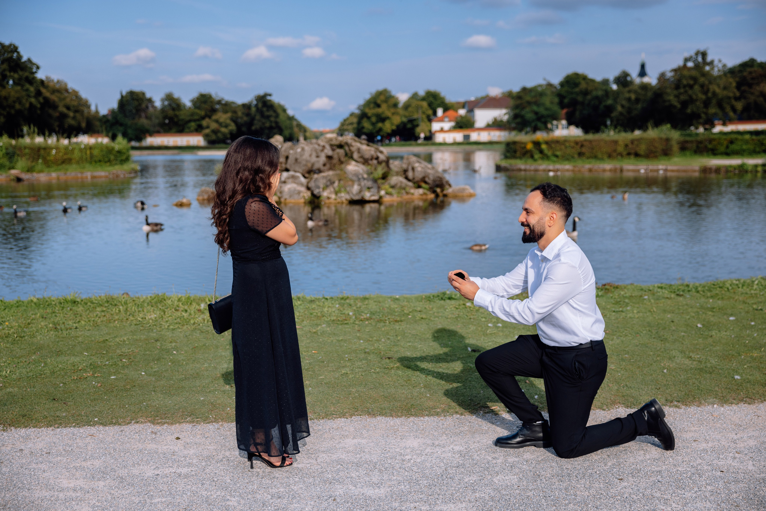 Bräutigam geht auf ein Knie und macht Heiratsantrag vor dem Schloss Nymphenburg