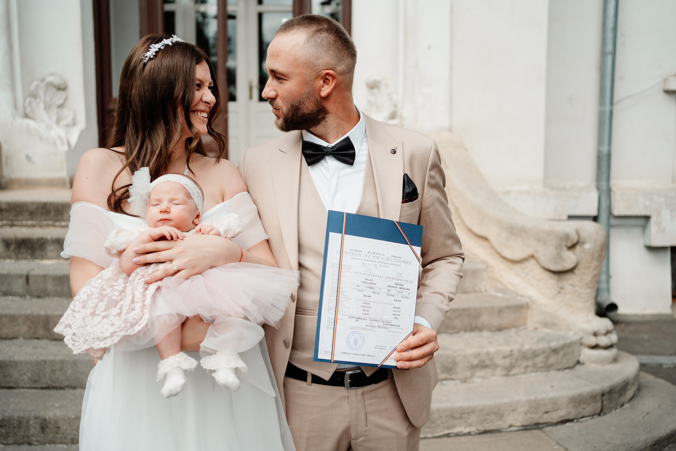 Miri fericiți în fața oficiului stării civile din Bucuresti, Sector 1, celebrând începutul unei noi vieți împreună. Fotografie de cununie civilă, capturând naturalețea și bucuria momentului special.