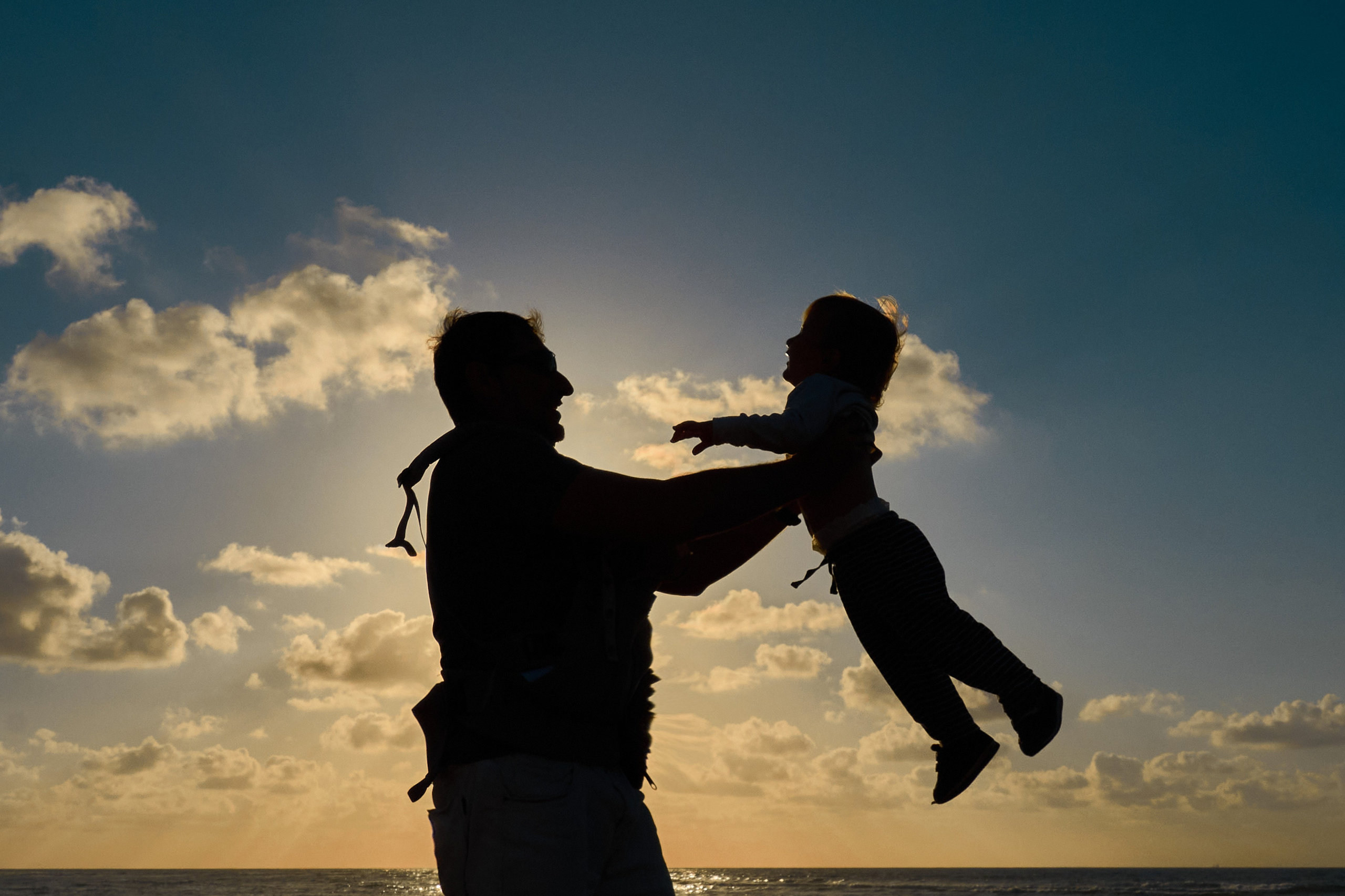 Папа подбрасывает ребёнка в воздухе на закате — семейная фотосессия в Дрездене