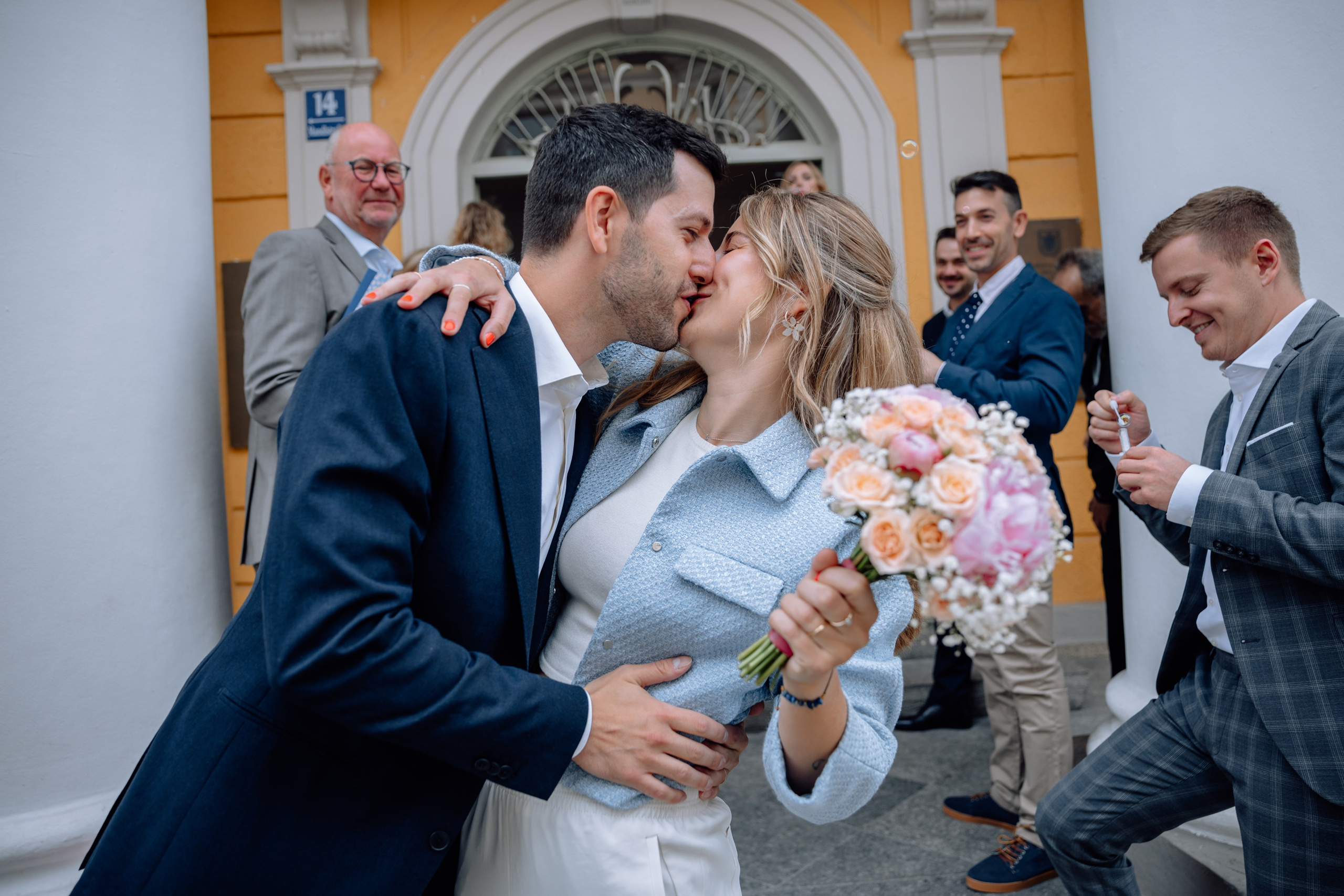 Braut auf dem Rücken des Bräutigams – verspielter Moment vor dem Standesamt Schwabing