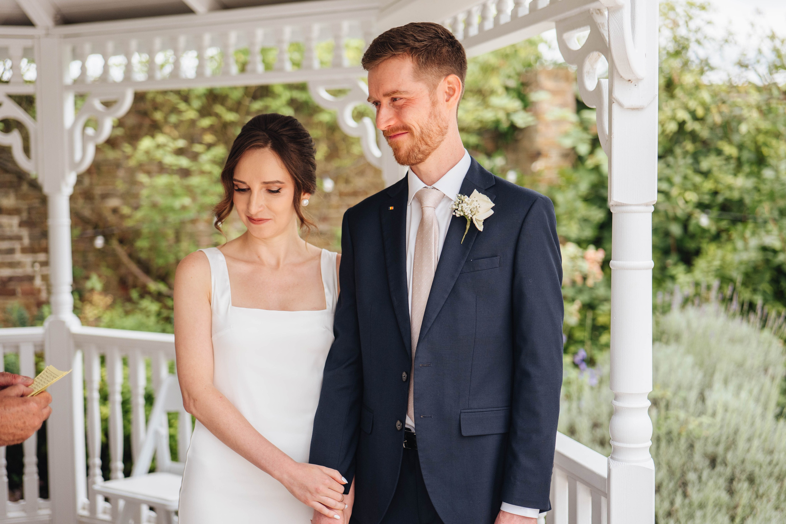 bride and groom at the ceremony, holding hands