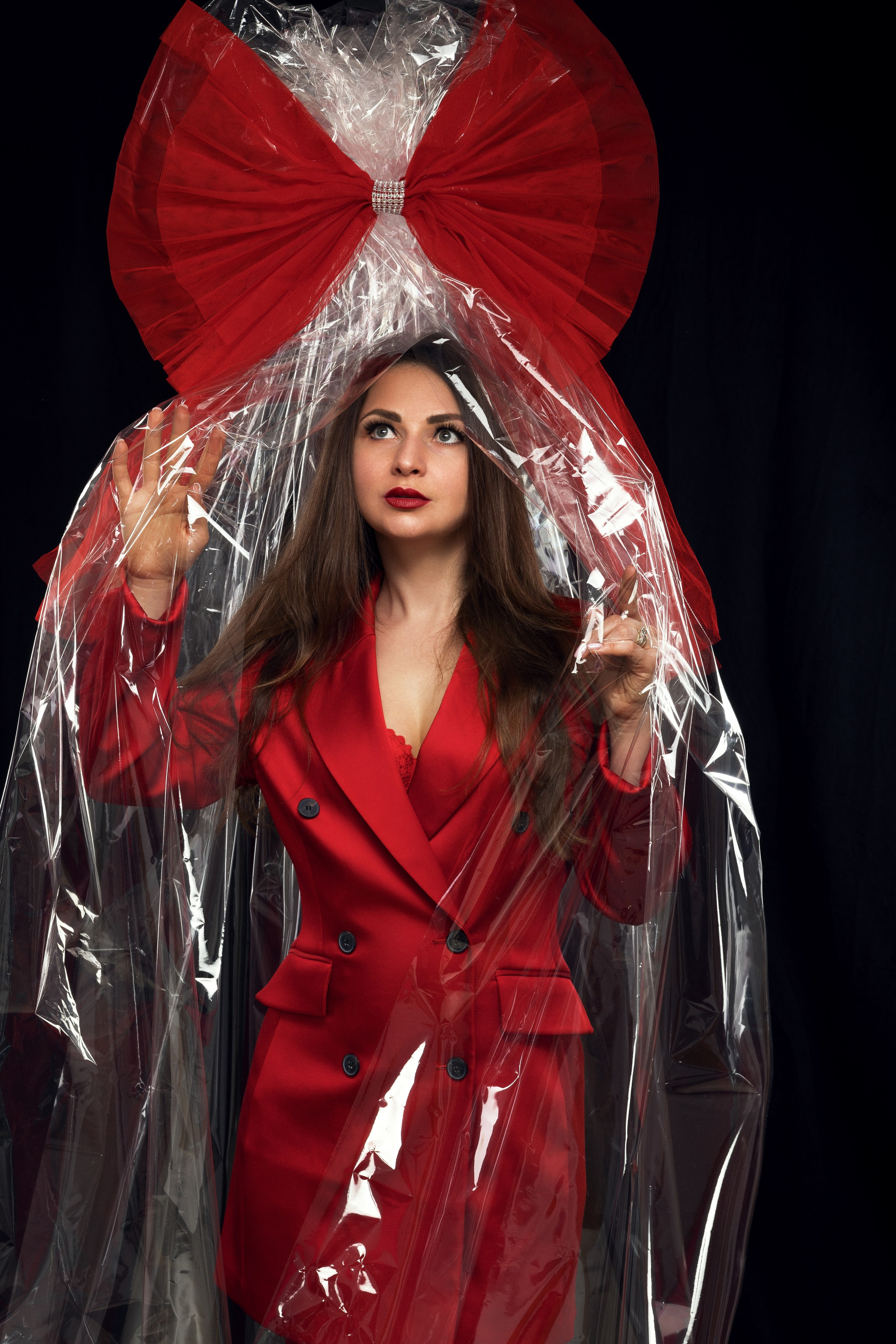 Studioaufnahme mit rotem Komplett-Look, stilisiert als eingepackte Puppe