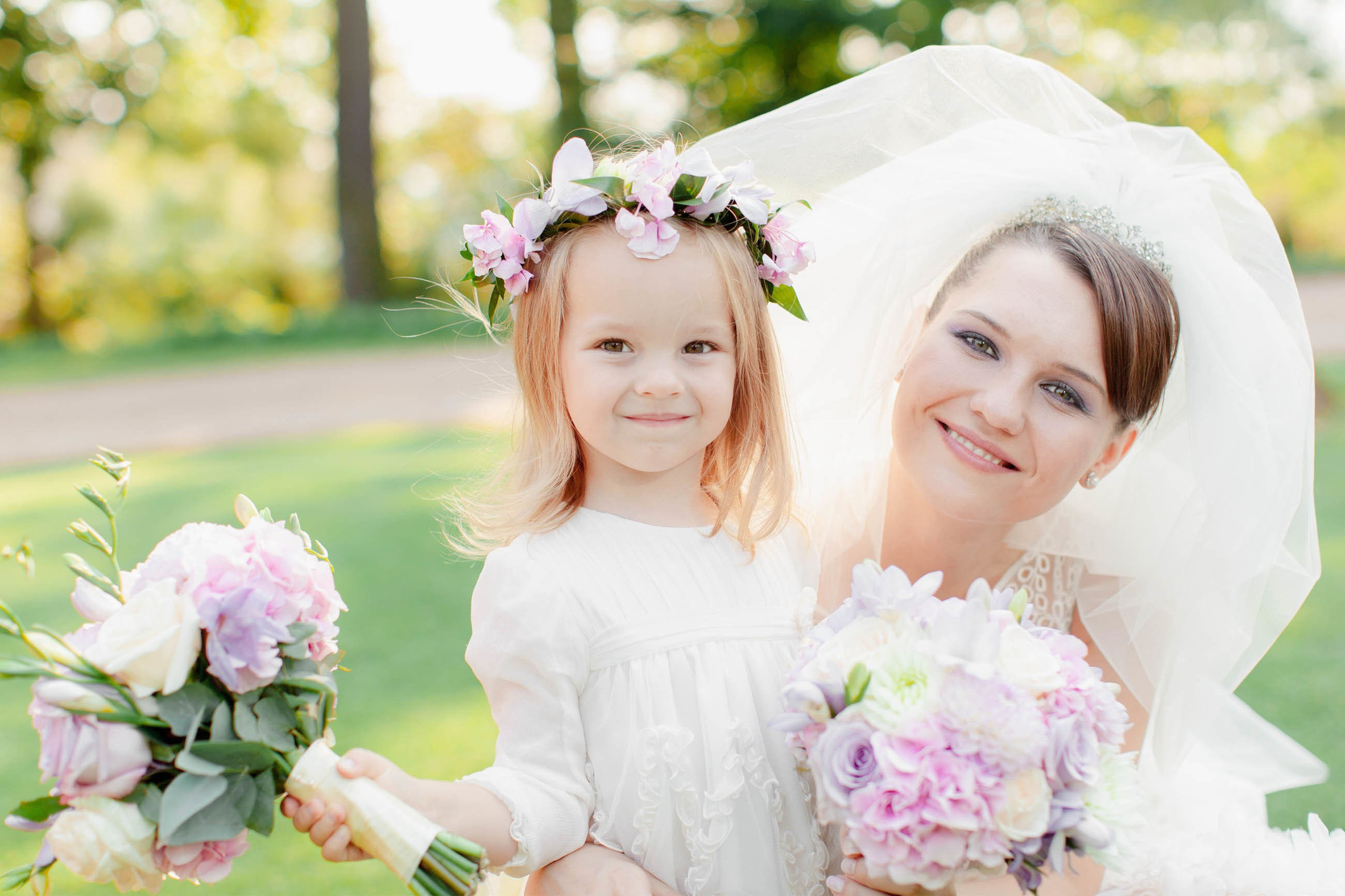 Radiant bride and flower girl posing for a photo on scenic Chateau Mcely grounds.