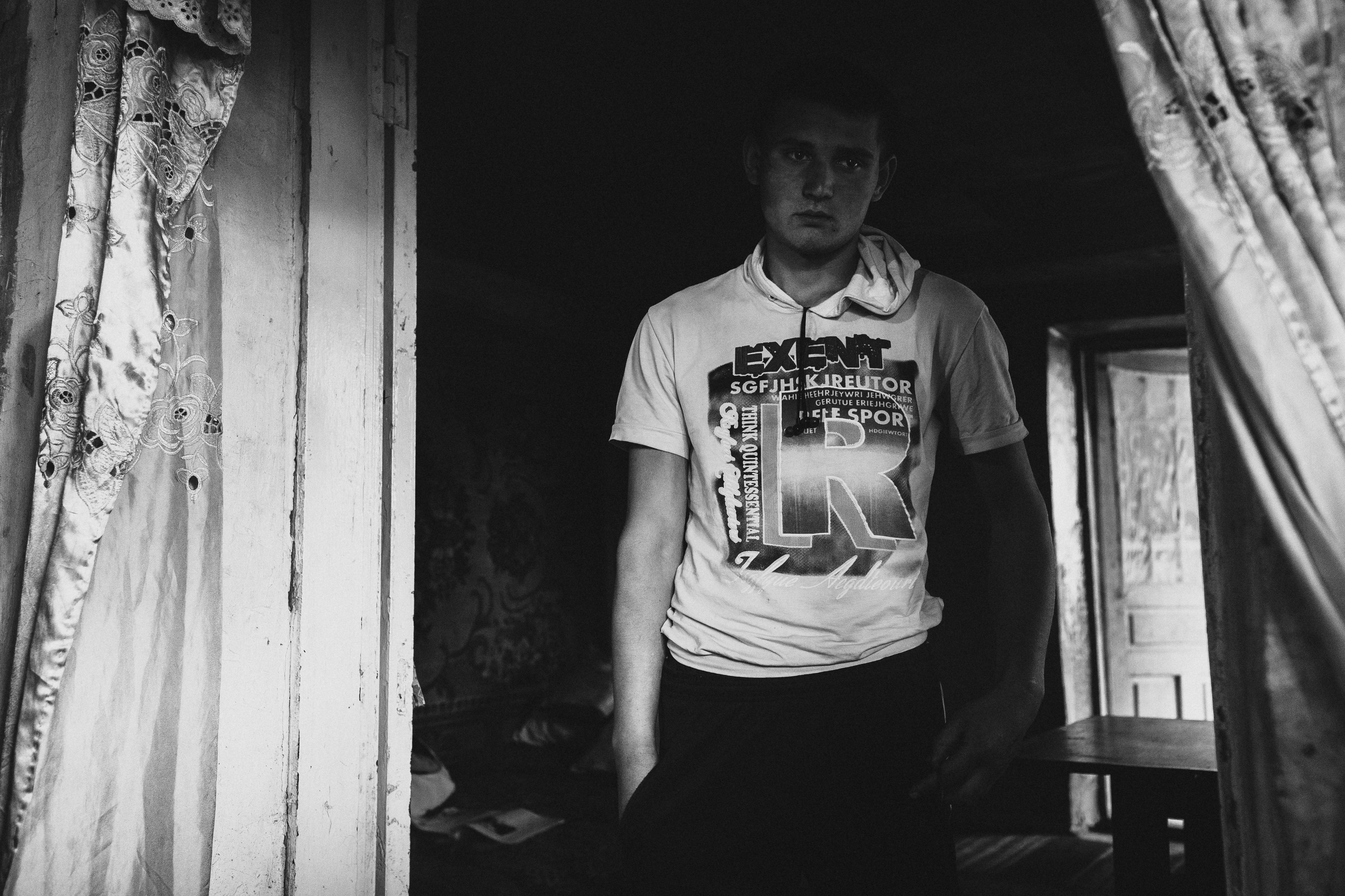 чёрно-белая социальная документальная фотография портрет бедность парень пятно света Фотограф в Ирландии