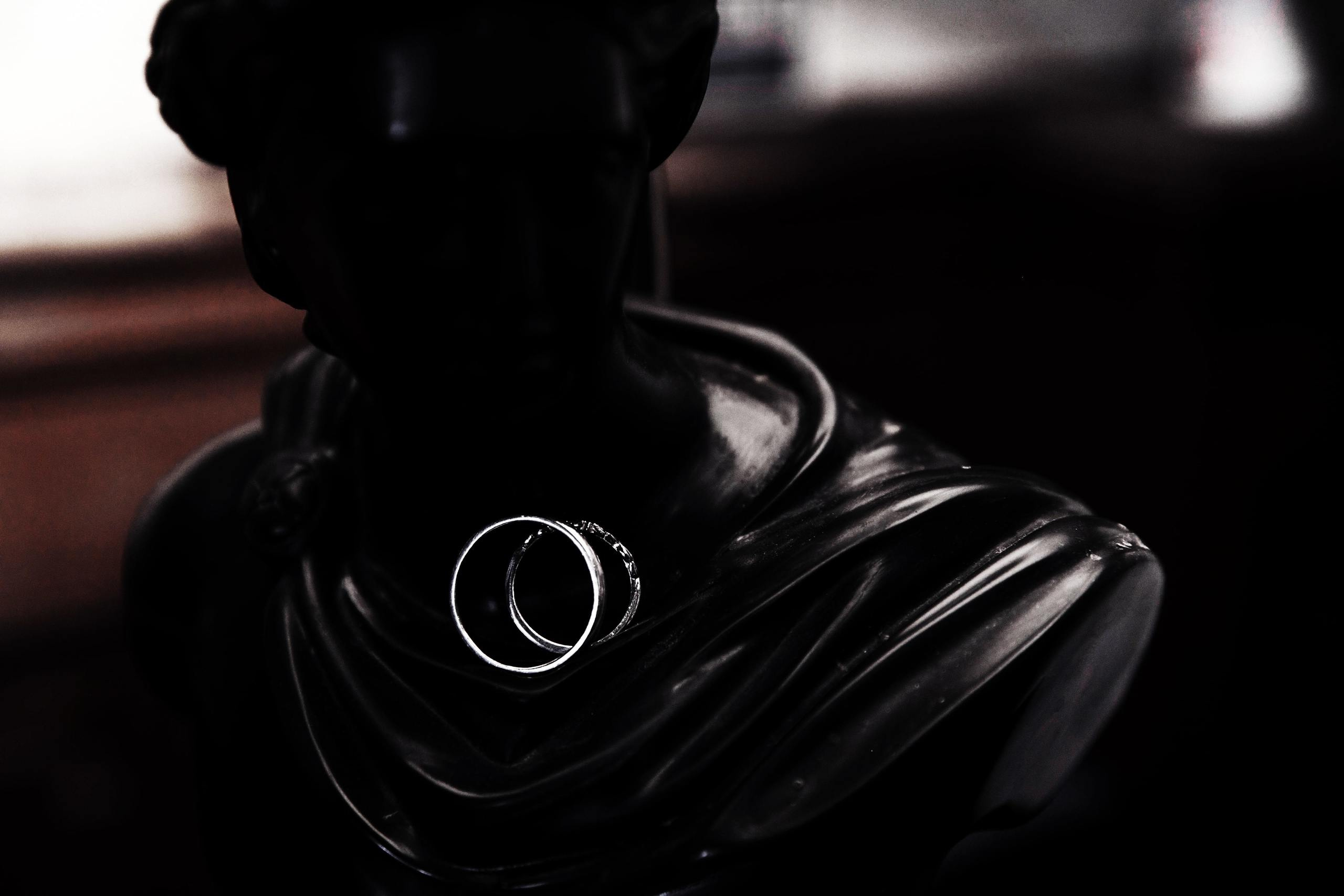 Die Eheringe liegen auf einer antiken Statue.