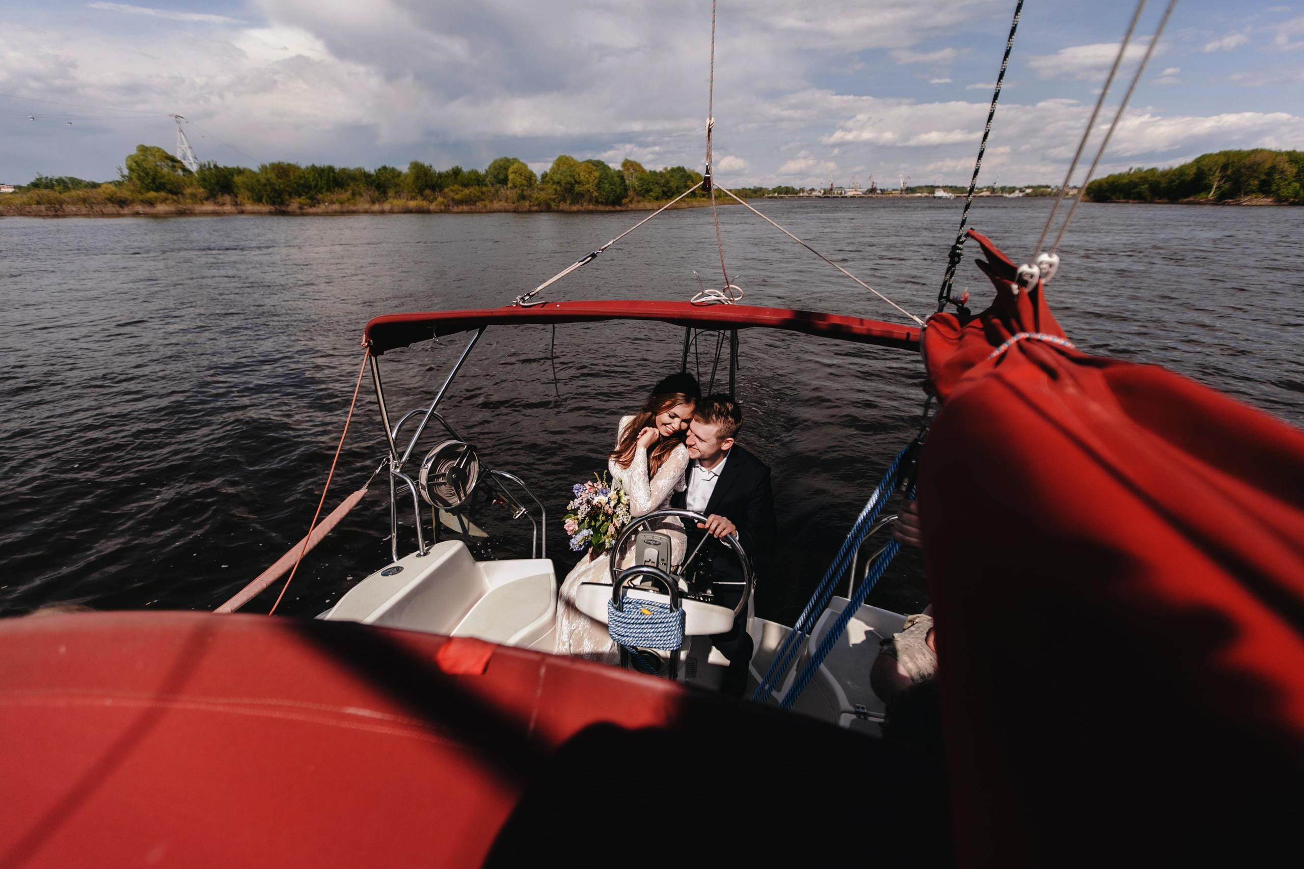 Braut und Bräutigam machen eine romantische Bootsfahrt auf dem Fluss.
