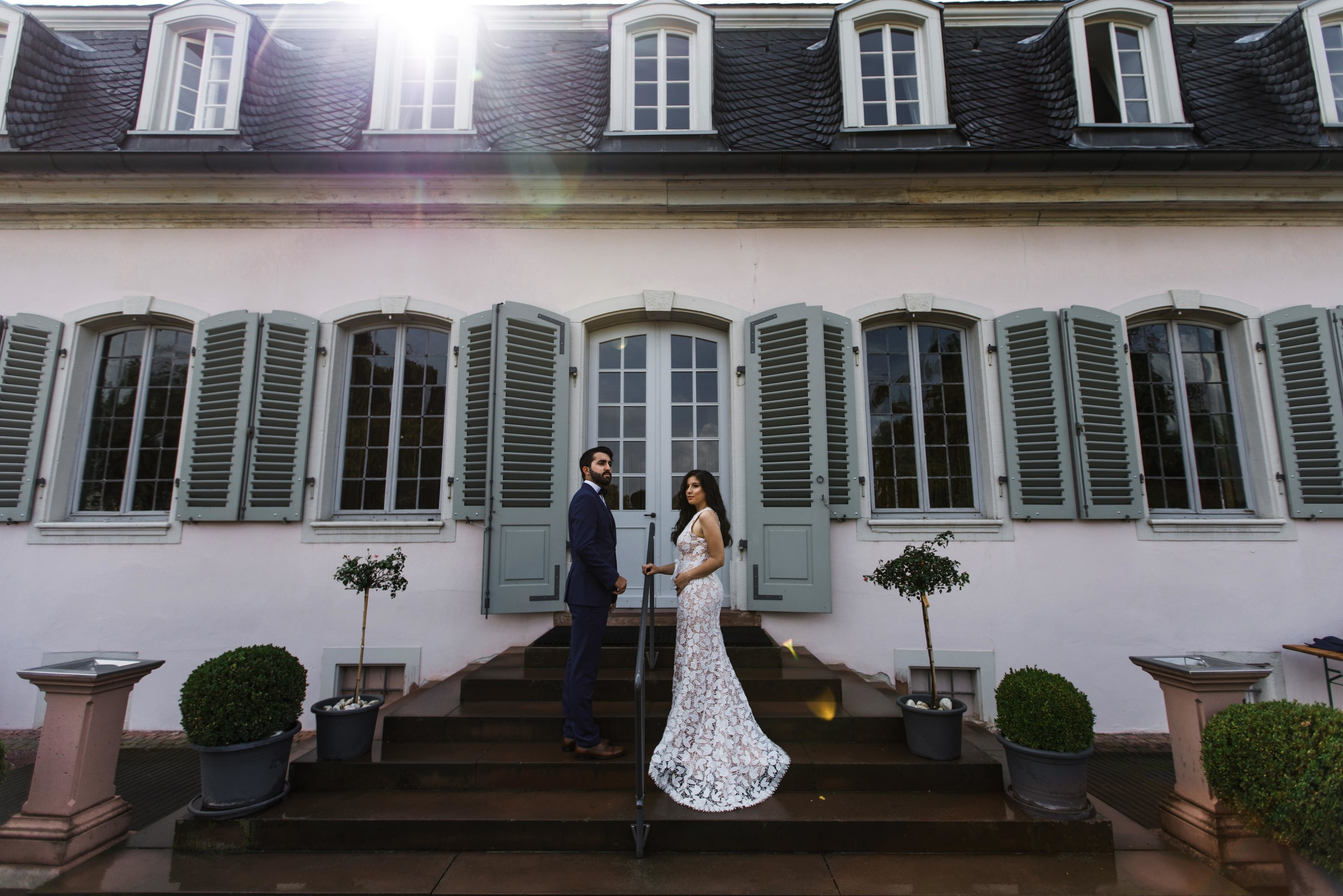 Bräutigam und Braut stehen auf der Treppe eines schönen historischen Gebäudes.
