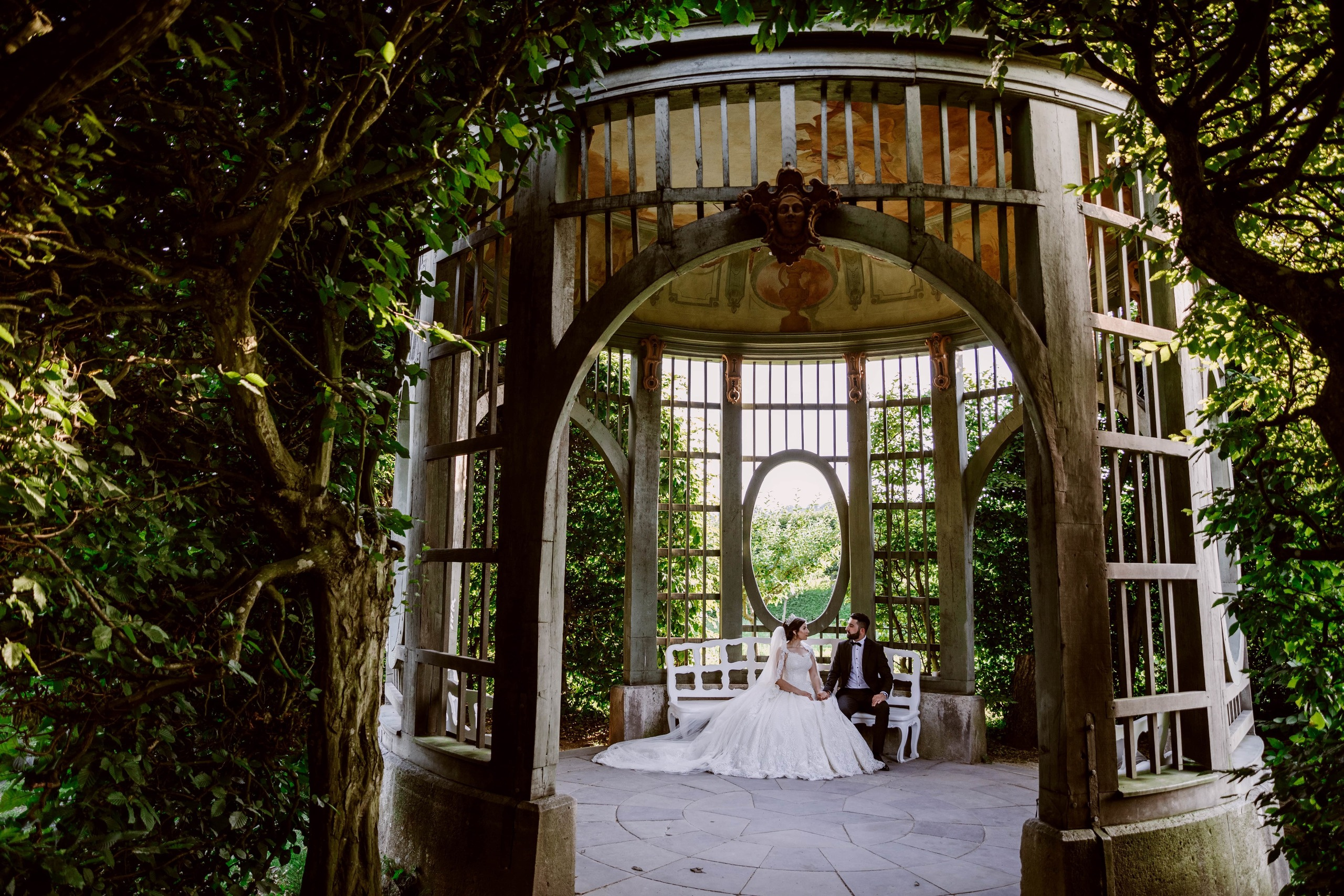 Bräutigam und Braut sitzen im Pavillon des Schlosses Veitshöchheim.