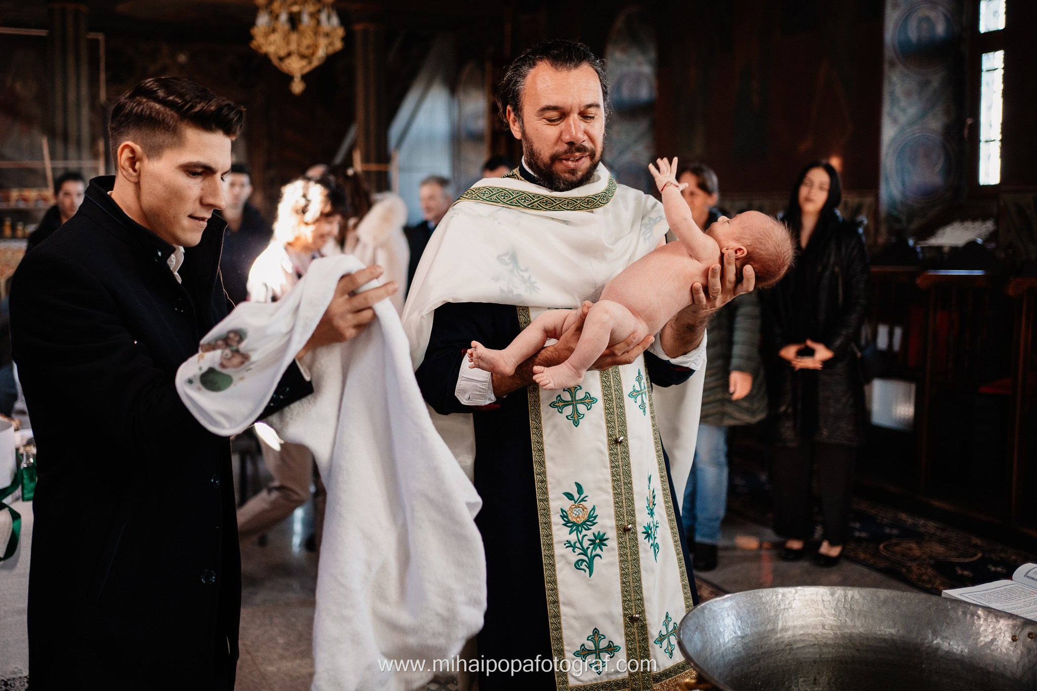 Instantaneu plin de tandrețe dintre părinți și bebeluș în ziua botezului, realizat în ilfov. Fotografie profesională de botez, capturând emoțiile autentice ale familiei într-un decor luminos și cald