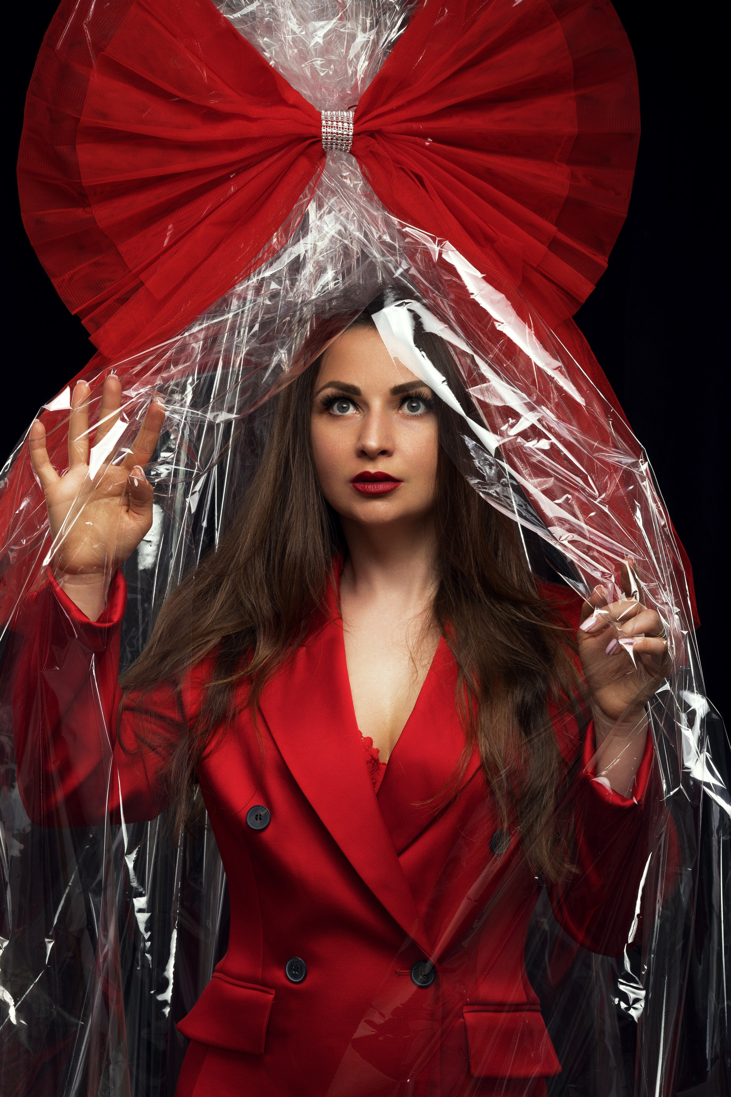 Anastasija im auffälligen roten Outfit, inszeniert als Puppe in Geschenkverpackung