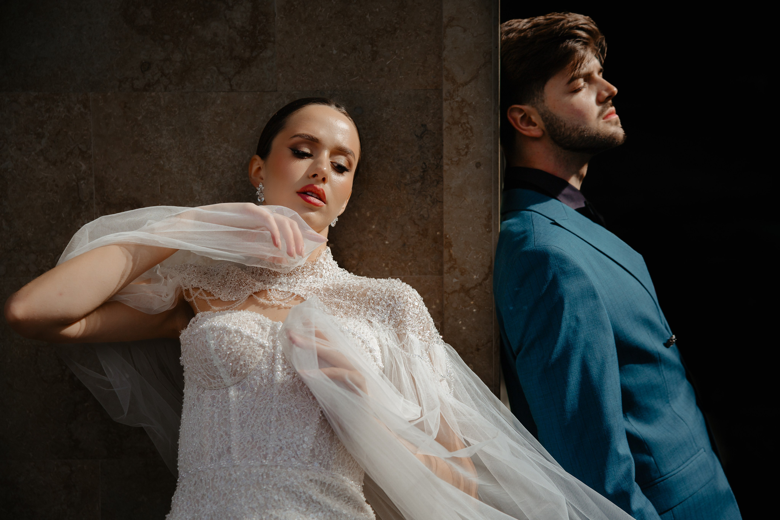 Mireasă cu voalul ridicat, alături de mire în costum albastru, portret de studio