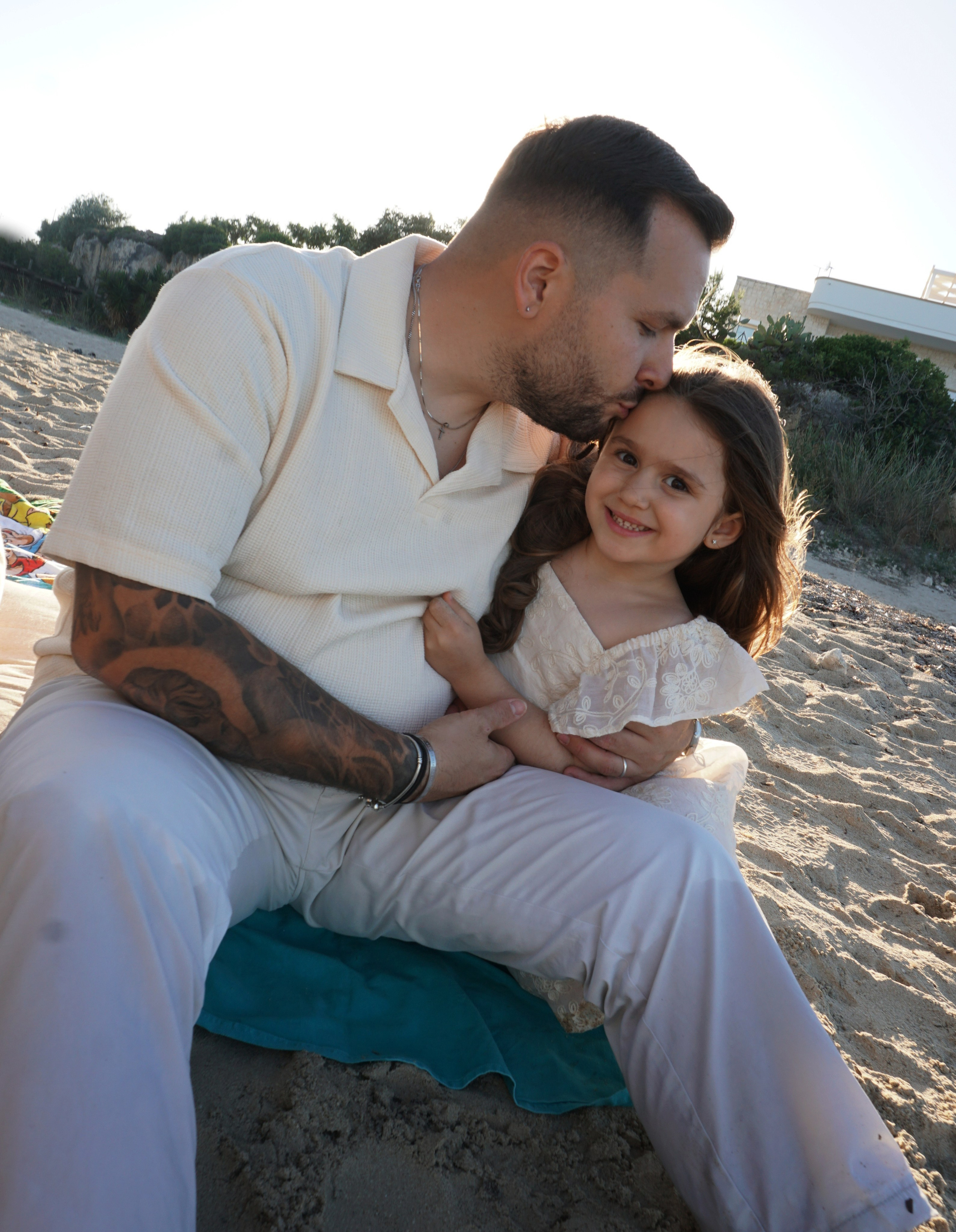 Famiglia che si tiene per mano guardando il mare turchese sotto il sole pugliese.