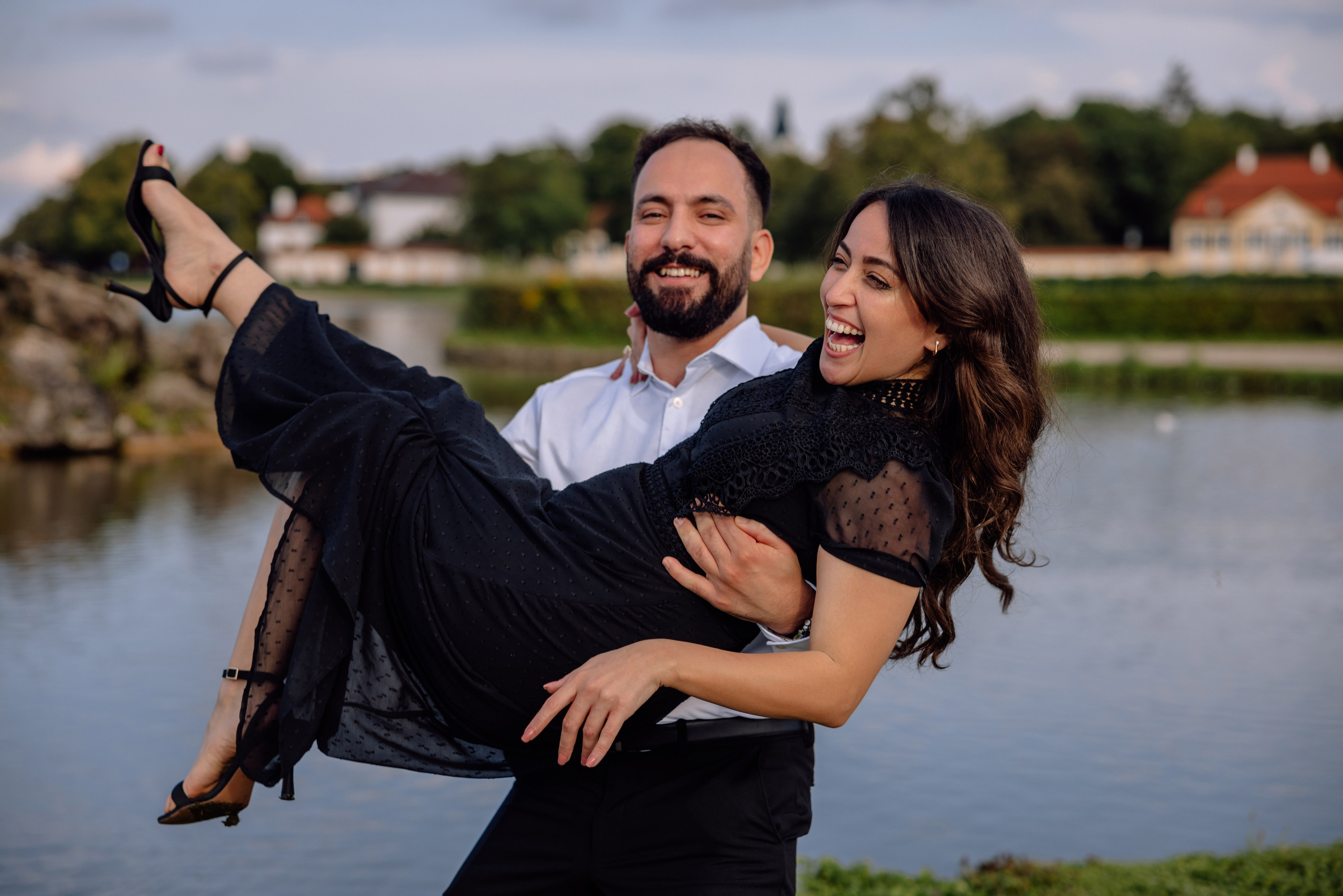 Bräutigam hält die Braut fest auf den Armen vor dem Schloss Nymphenburg