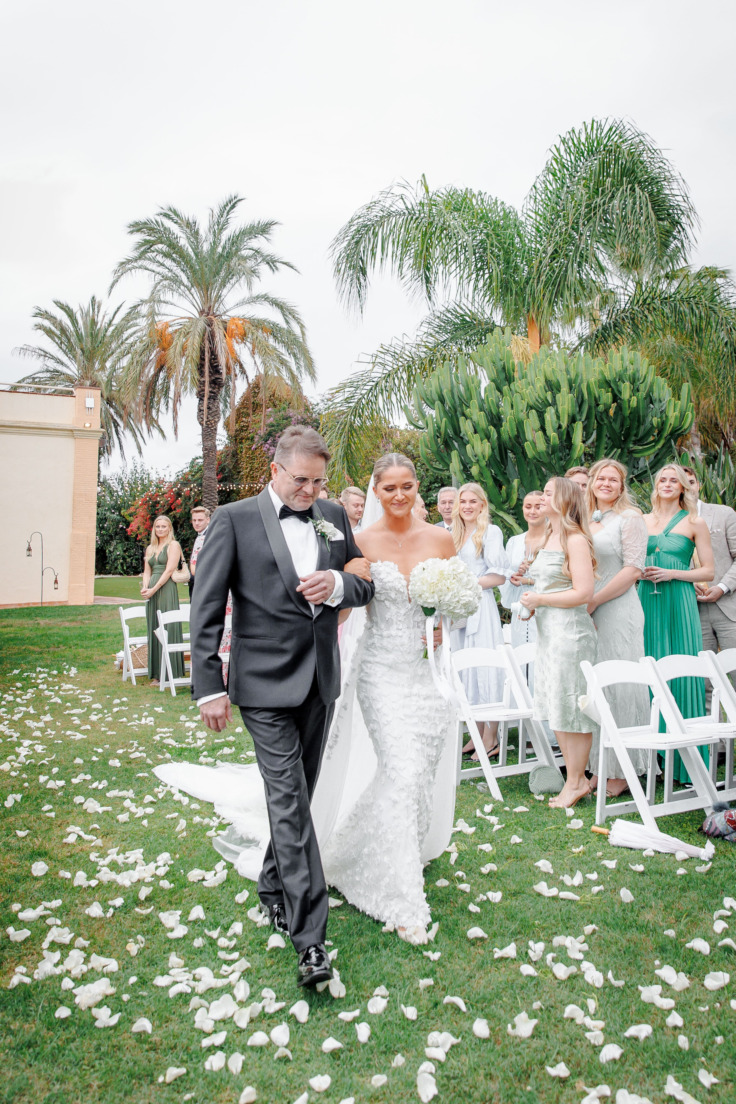 The bride and father walk down the aisle before the ceremony starts. 