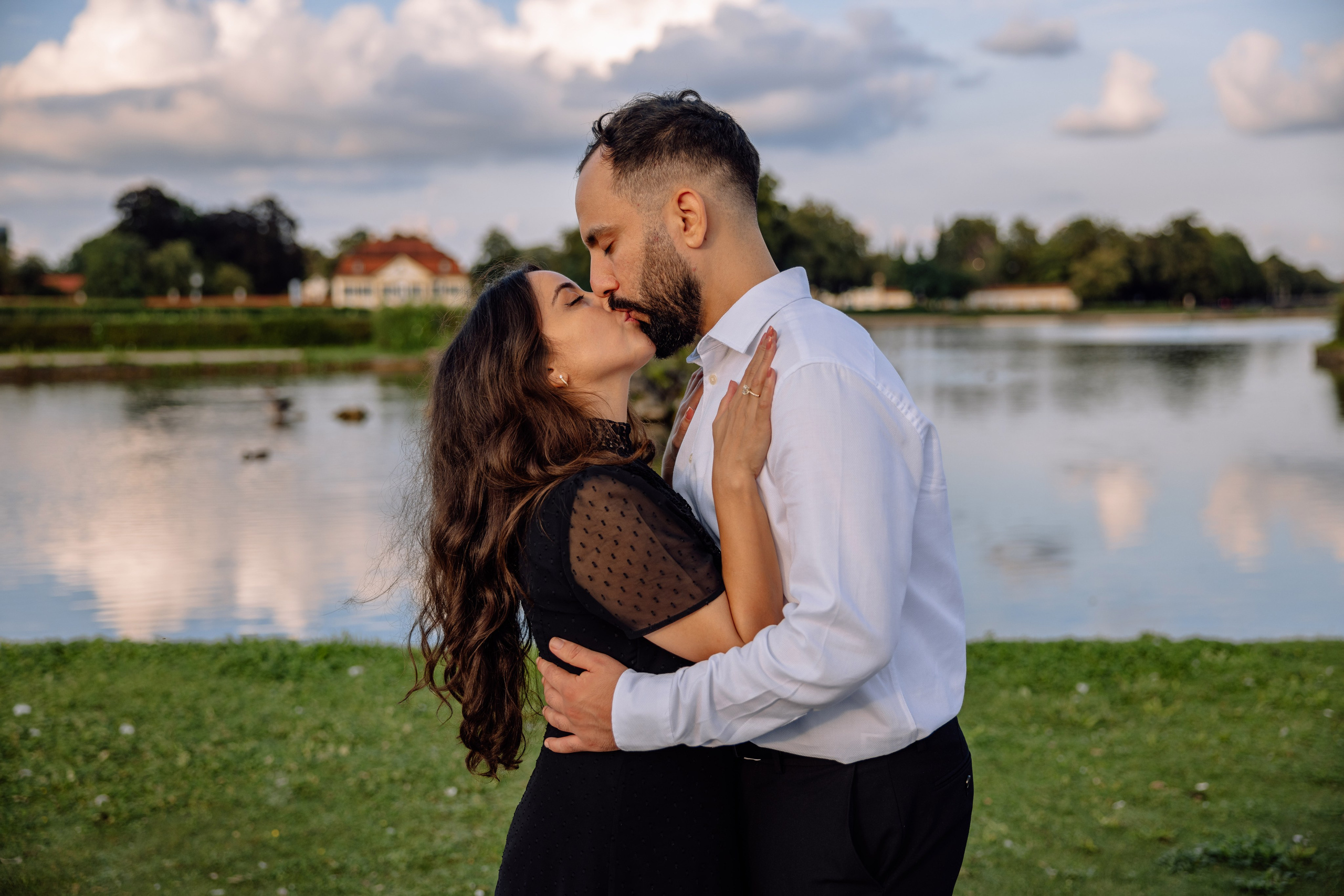 Braut und Bräutigam küssen sich zärtlich vor dem Schloss Nymphenburg